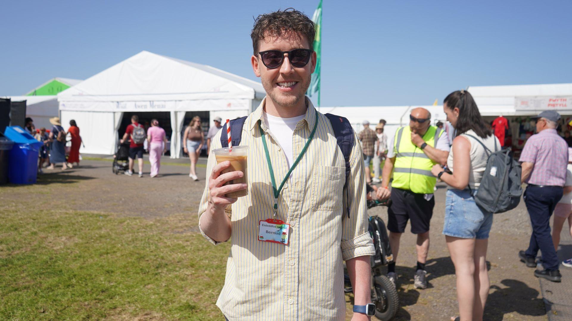 Meilir Rhys Williams, beriniad y gystadleuaeth Perfformio Golygfa i flwyddyn 10 a dan 19 oed yn mwynhau coffi oer cyn y cystadlu. Dywedodd Meilir "bod y 'Steddfod yn llwyddiant aruthrol yn barod".