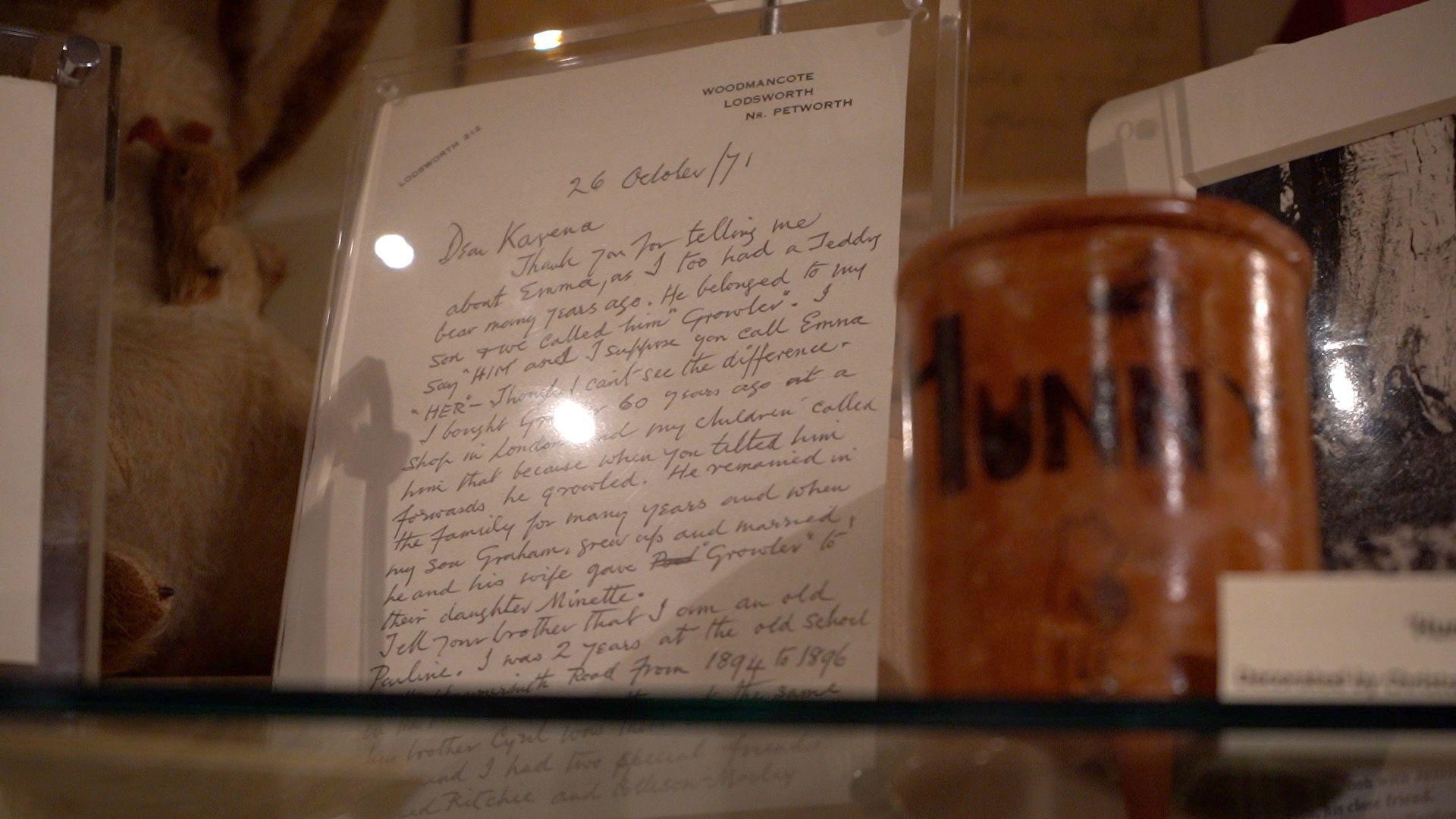 A framed letter on display. There are other items around it.