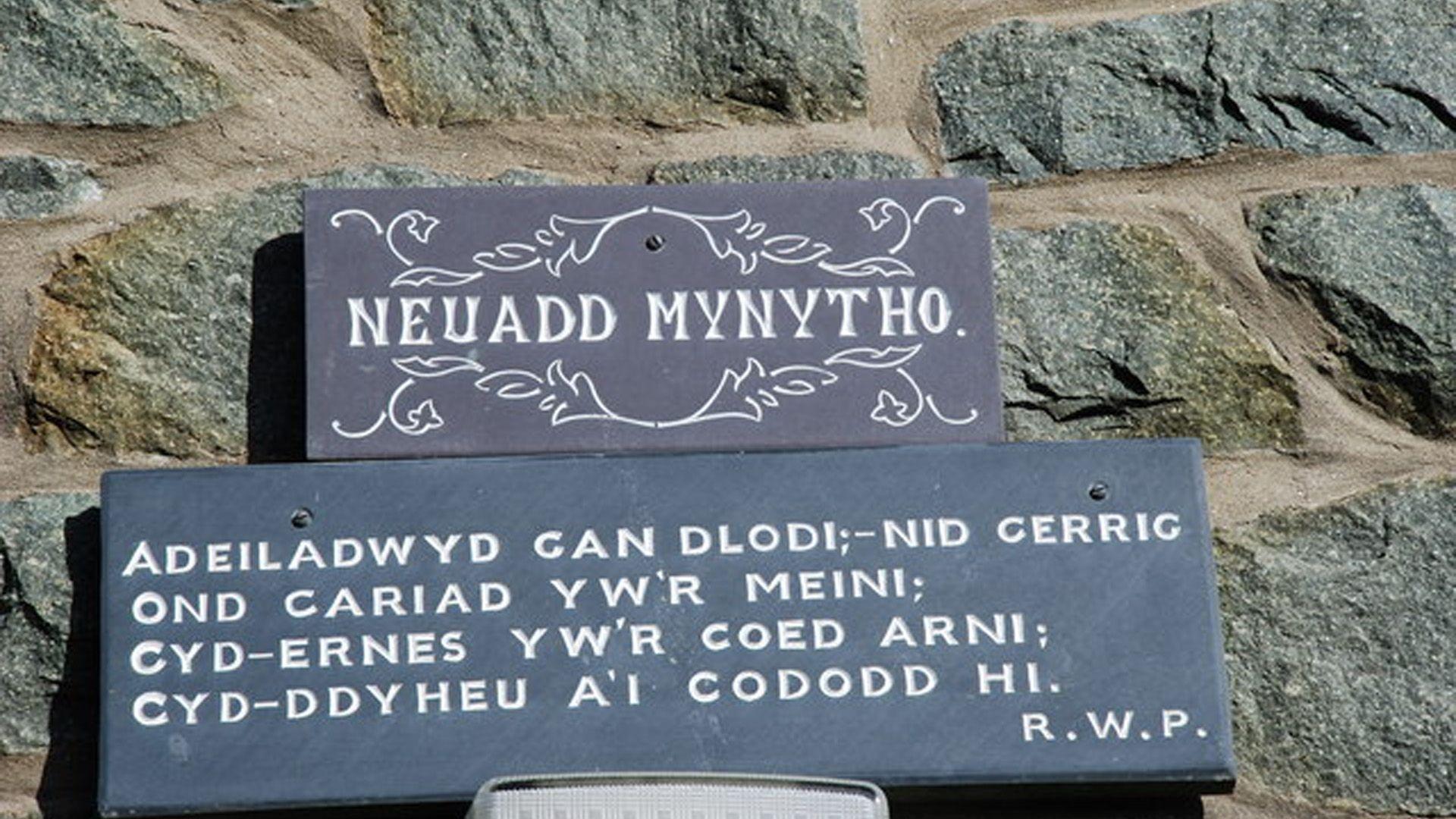 Y plac tu allan i'r neuadd gydag englyn R Williams Parry arno