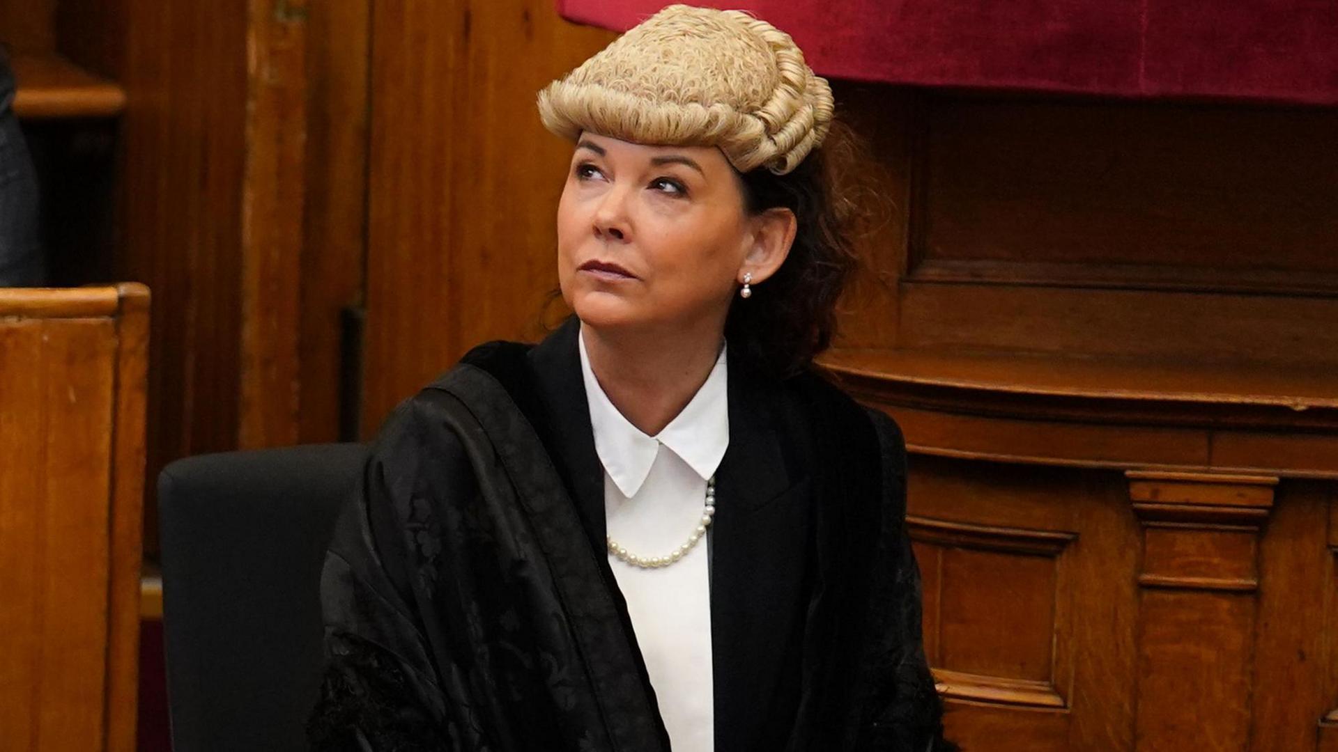 Dorothy Bain KC pictured in the Court of Session in Edinburgh wearing black legal robes, white wig and a white blouse. She is seated and looking up to her right. 