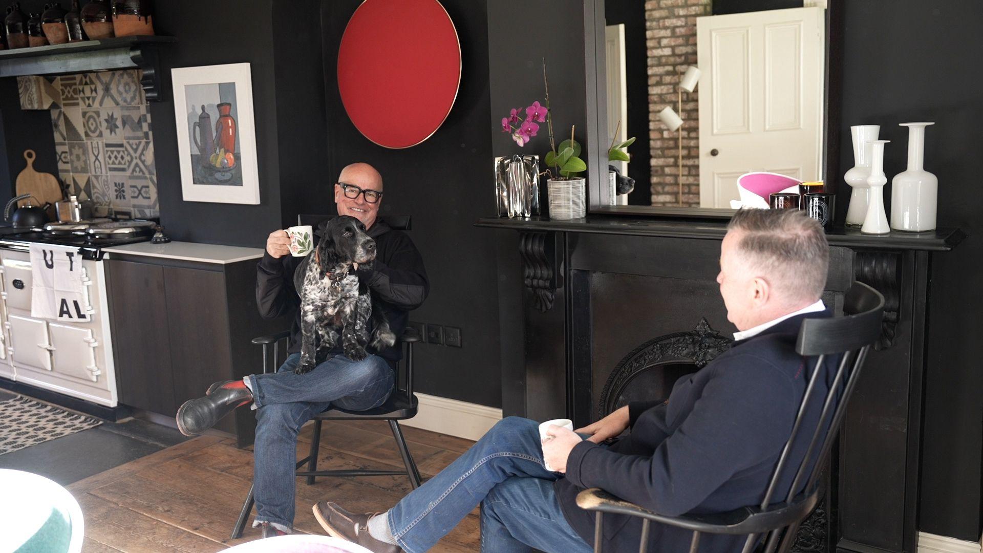 Anthony â Llwyd ar ei lin a David yn yfed paned yn y gegin