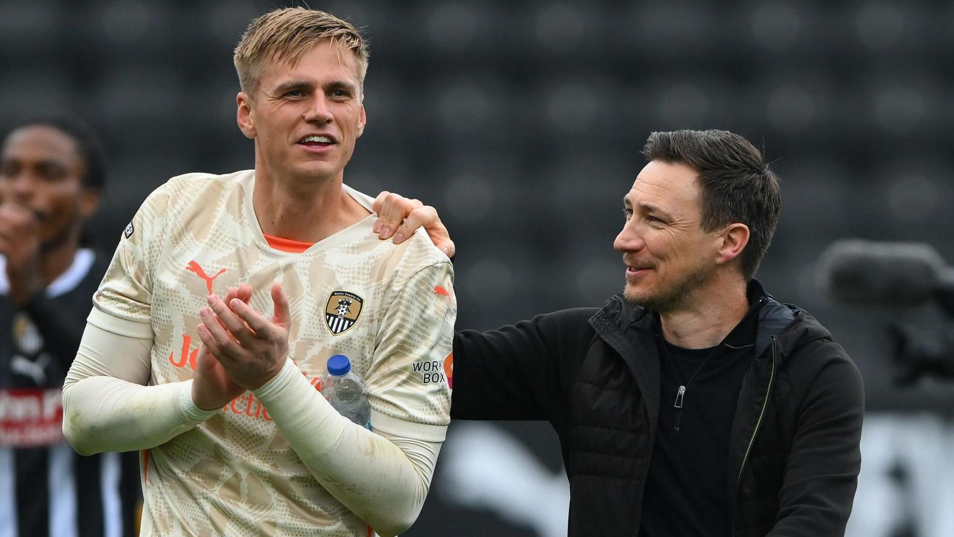 Notts County goalkeeper Alex Bass gets a pat on the back from manager Stuart Maynard