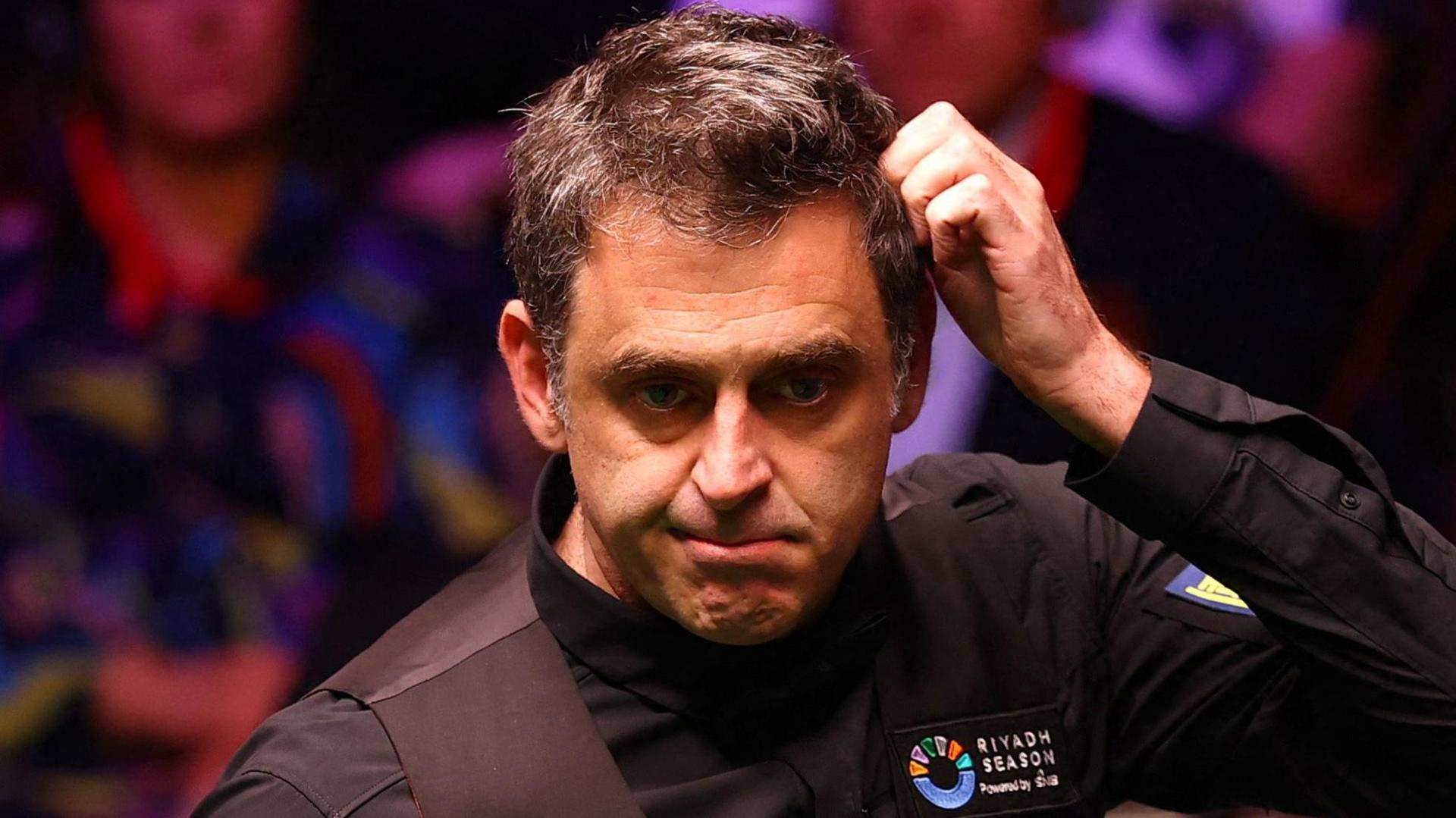 Ronnie O'Sullivan scratches his head during his match against Zhao Xintong at the World Snooker Championship