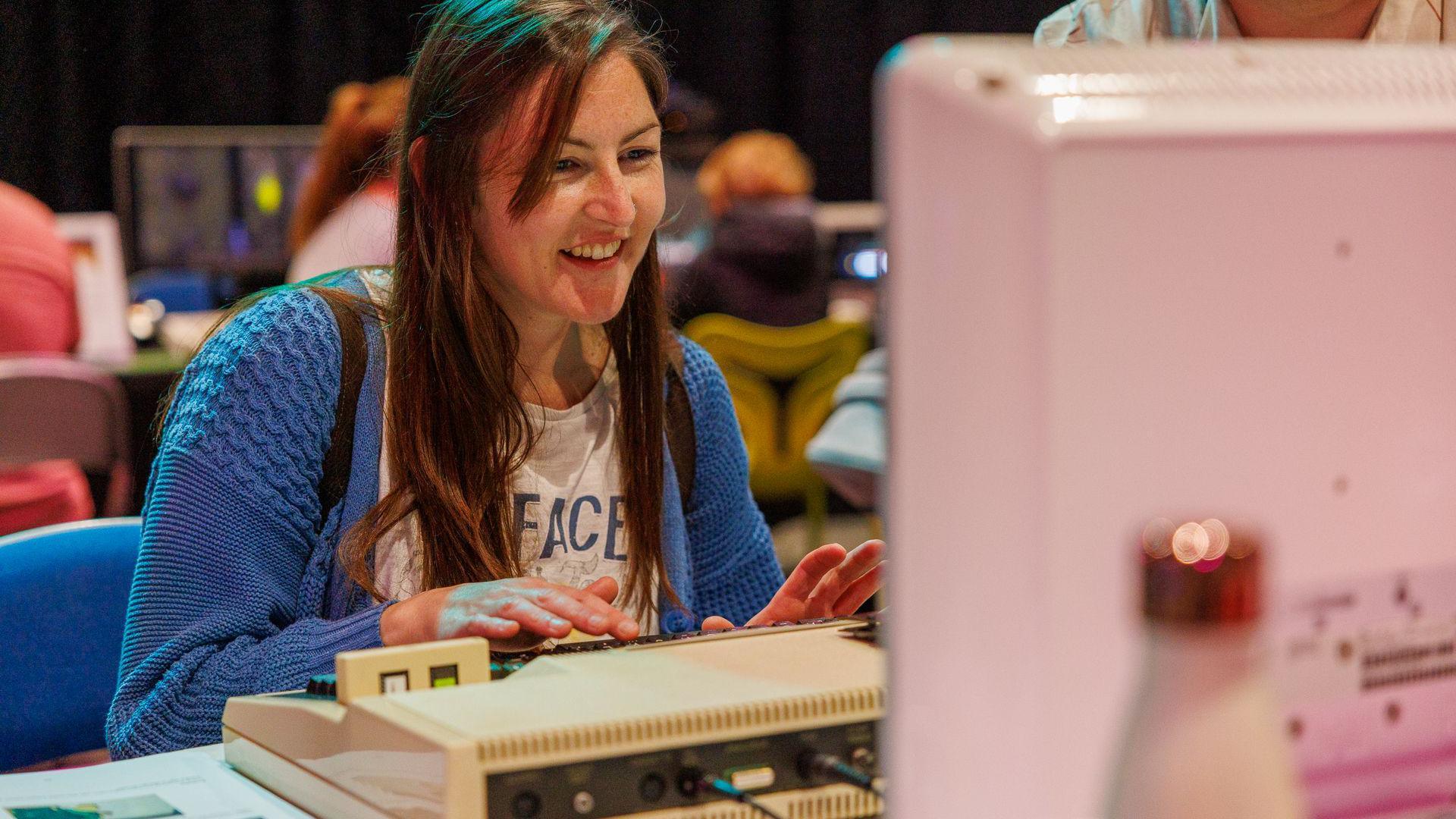 A woman playing on a retro computer