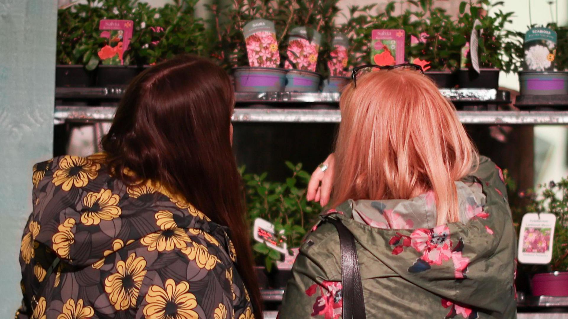 Women in floral print coats look at flowers on sale during the RHS Urban Show in Manchester