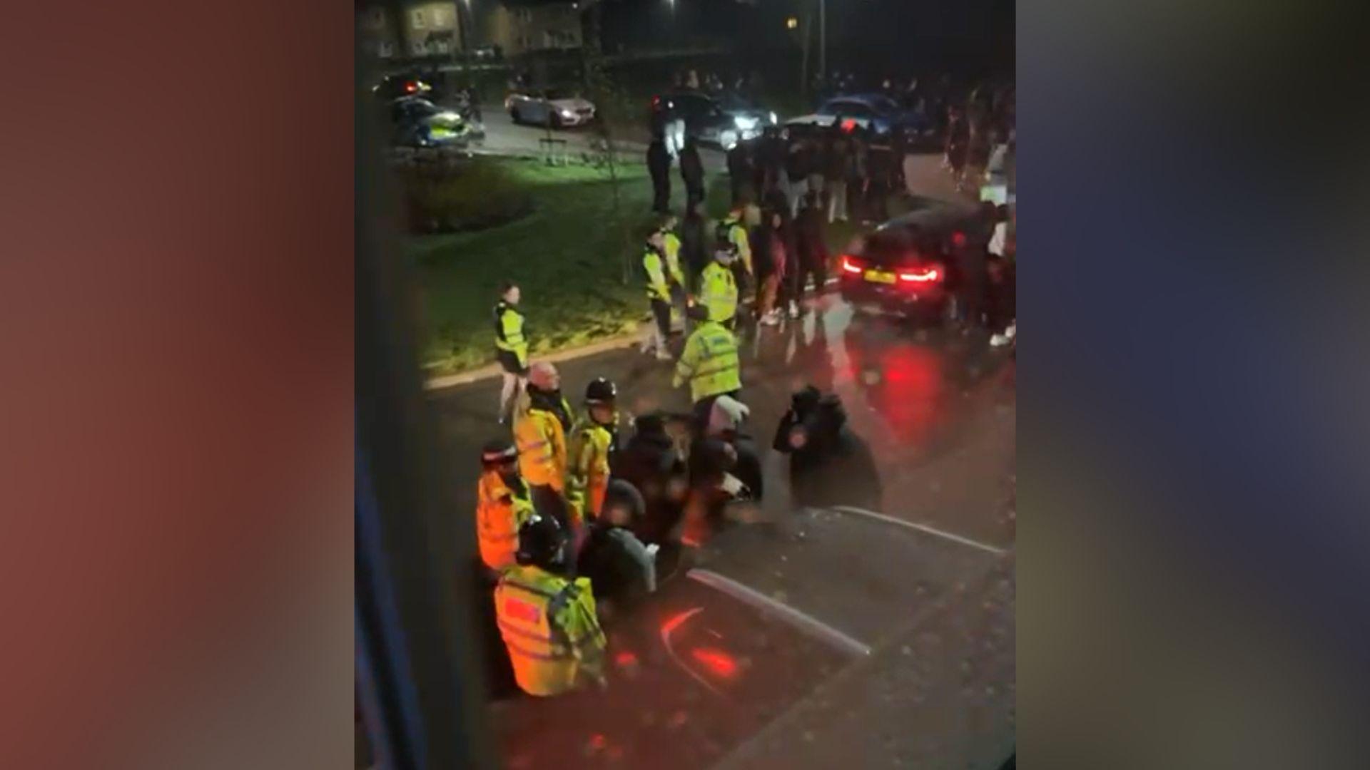 A still from footage shot from a nearby window showing swarming officers dispersing the crowds