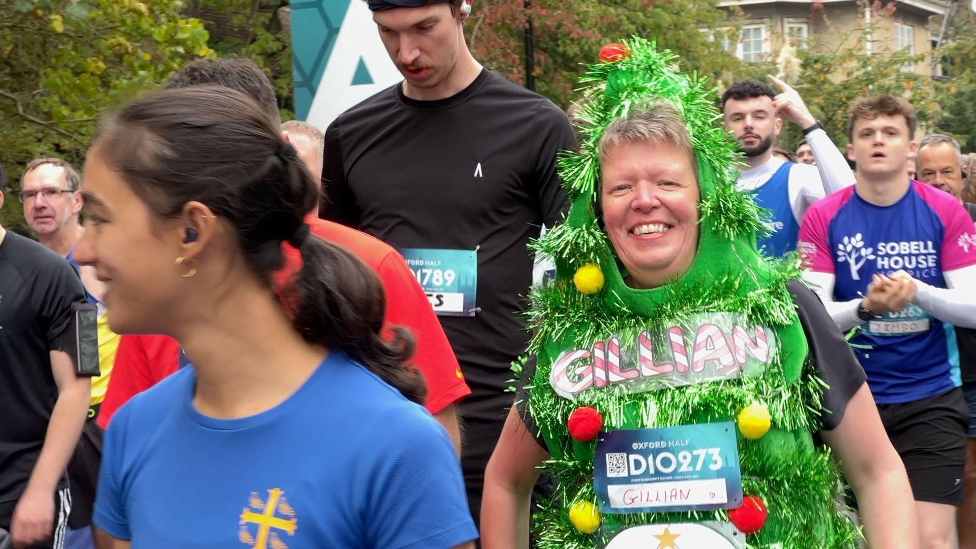 A woman dressed as a Christmas Tree runs the Oxford Half.