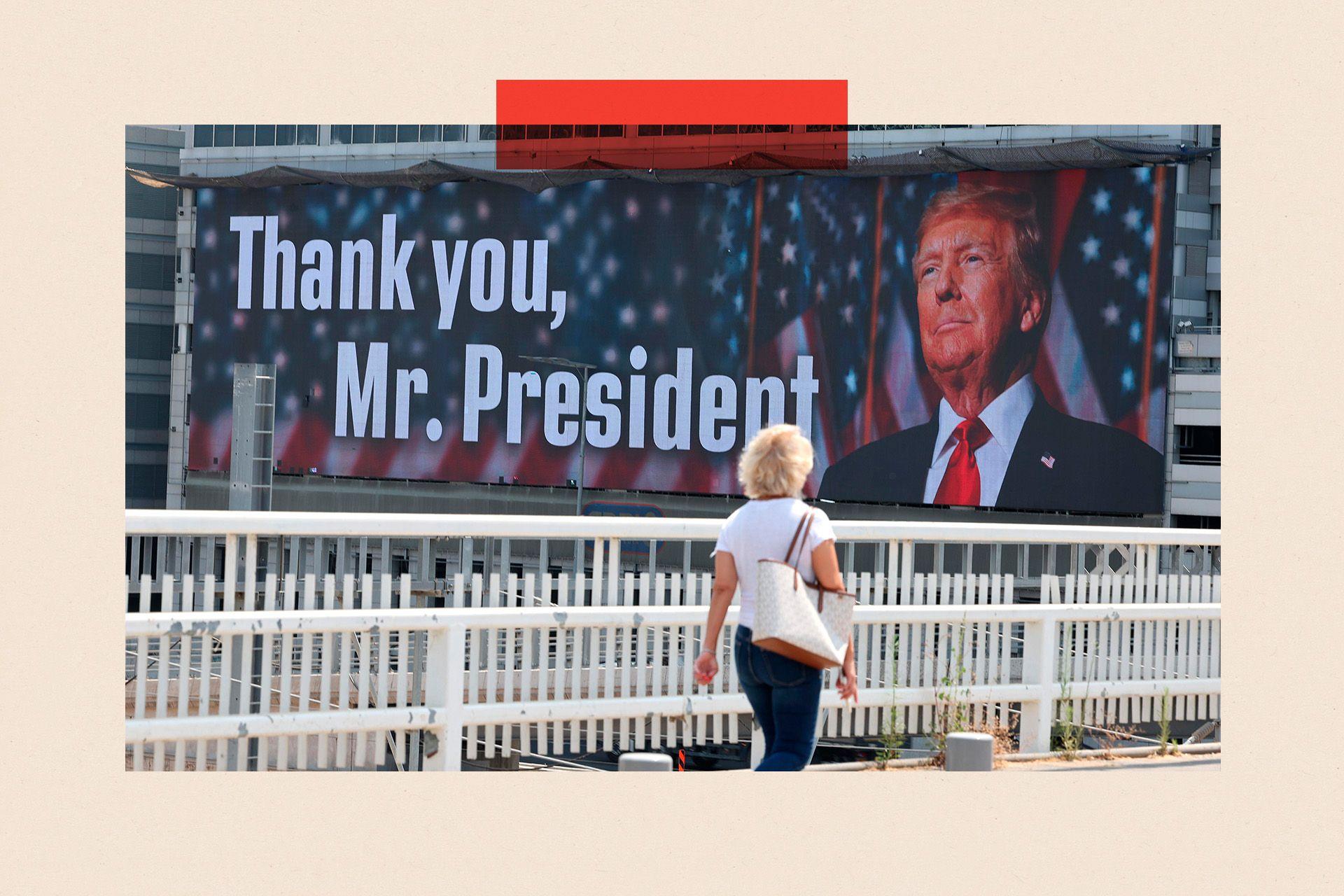 A woman walks past a large billboard that says Thank you, Mr President and shows Donald Trump's face