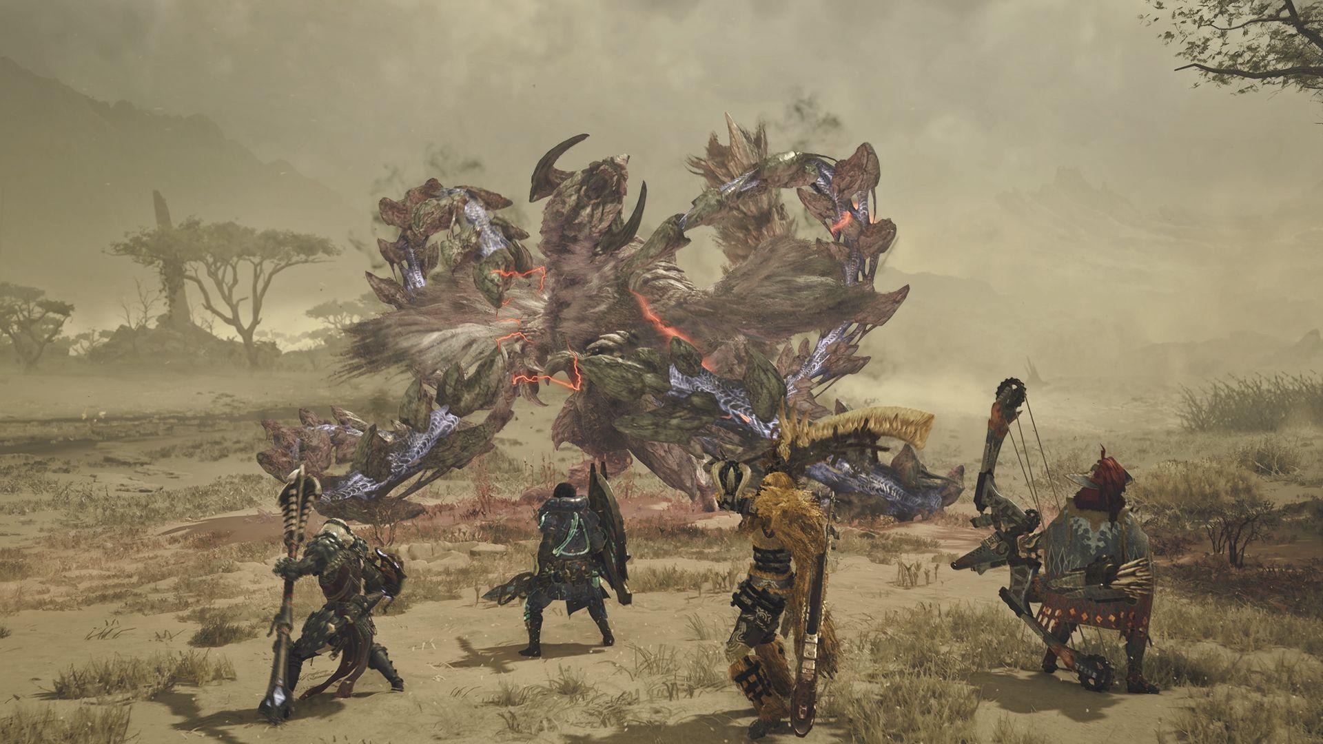 Screenshot shows a squad of four player characters in a dusty, desert environment facing off against a huge monster. It is bird-like, with feathers and a long neck, but also has armoured skin and scales along its four muscular limbs.