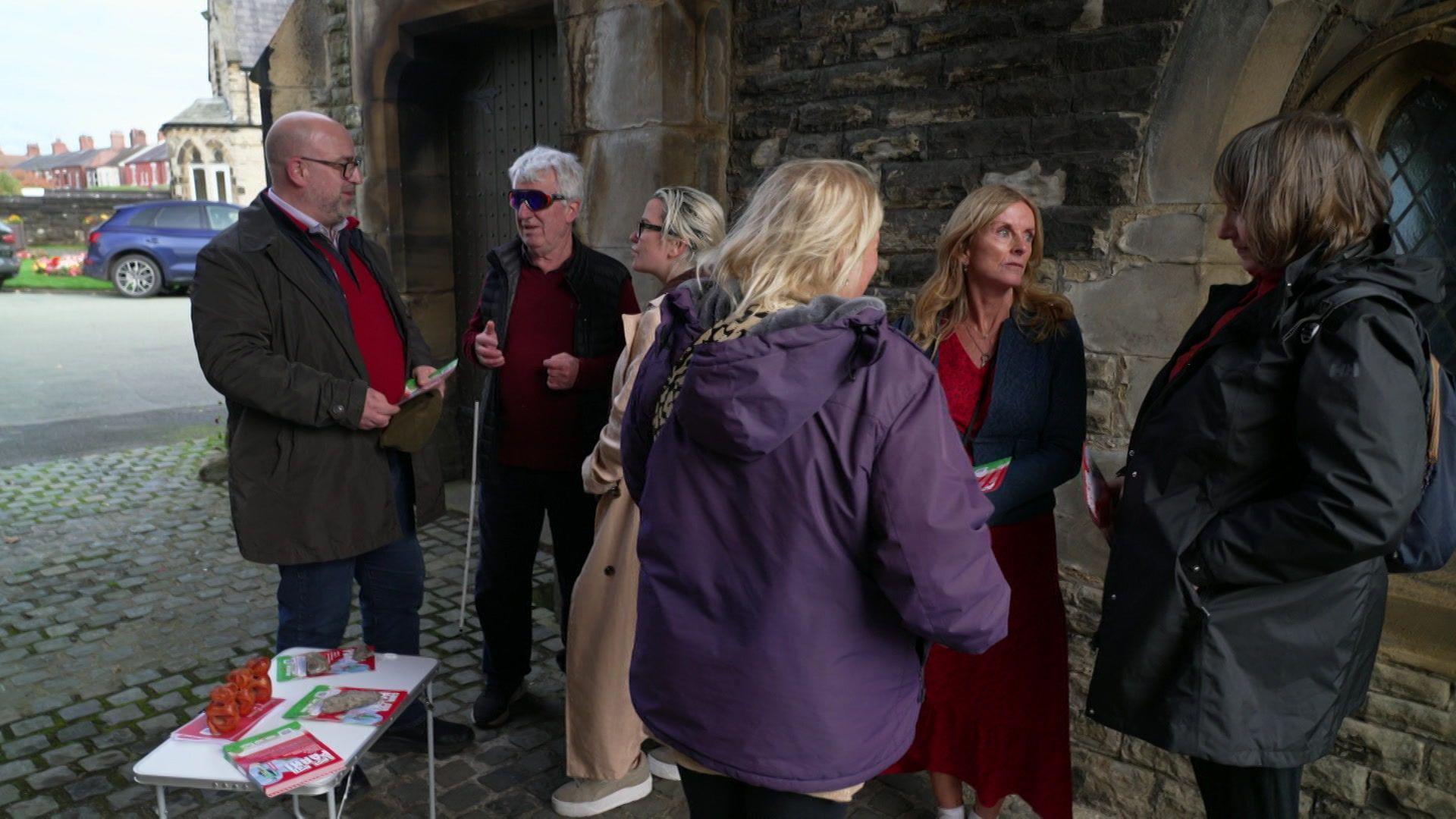 A group of campaigners outside Northwich Town Council's offices. A table carrying leaflets is pictured to the left of the group.