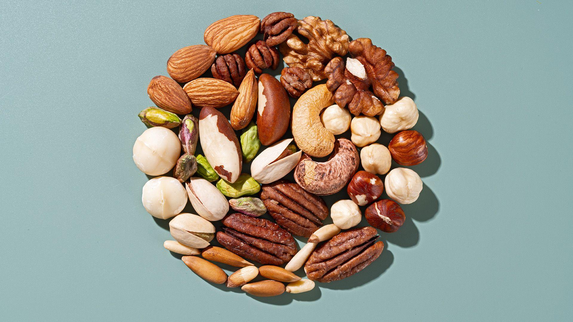 Assorted nuts in a circle on green background