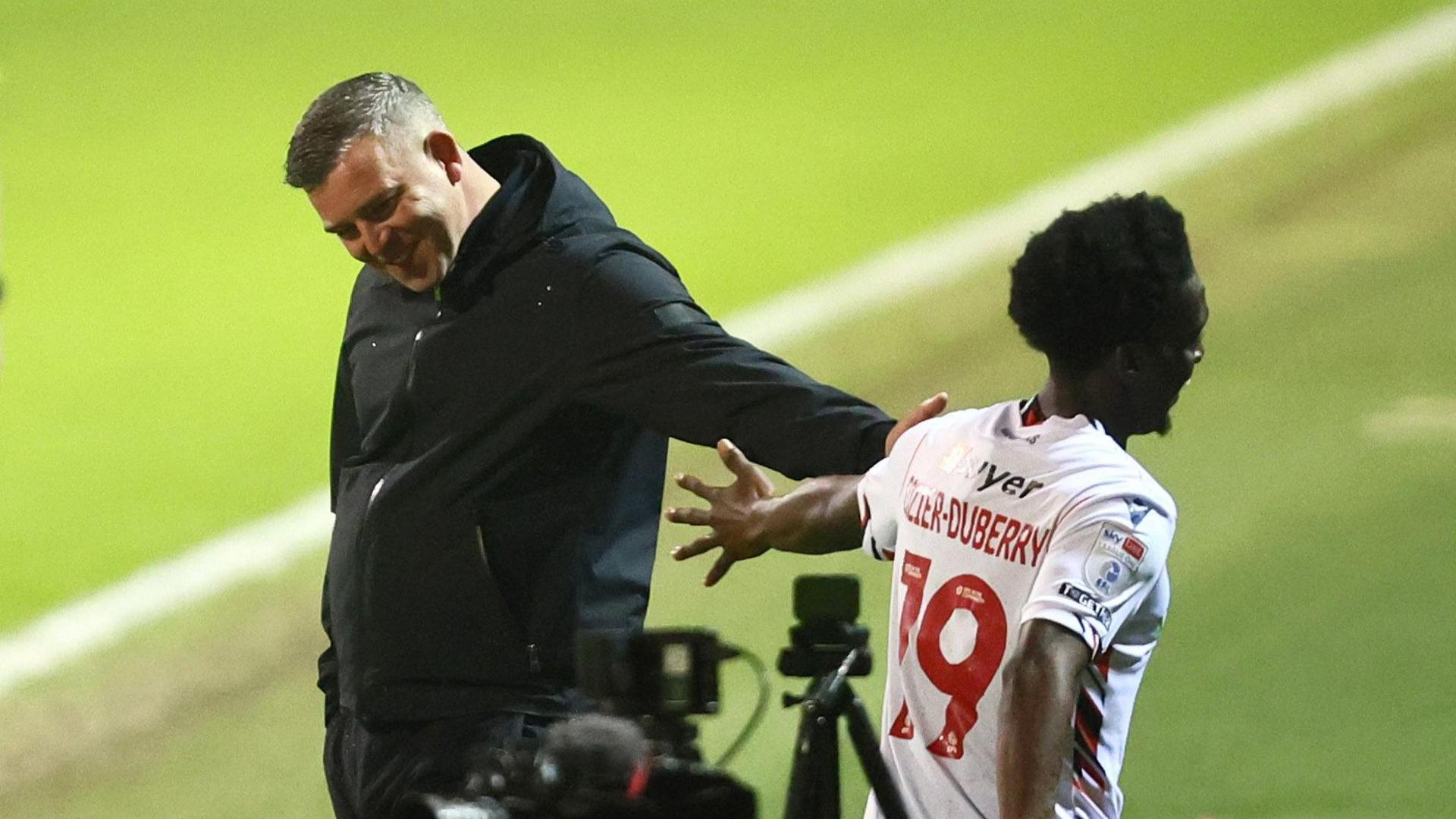Amario Cozier-Duberry celebrates scoring Bolton Wanderers' third goal against Stevenage with manager Steven Schumacher