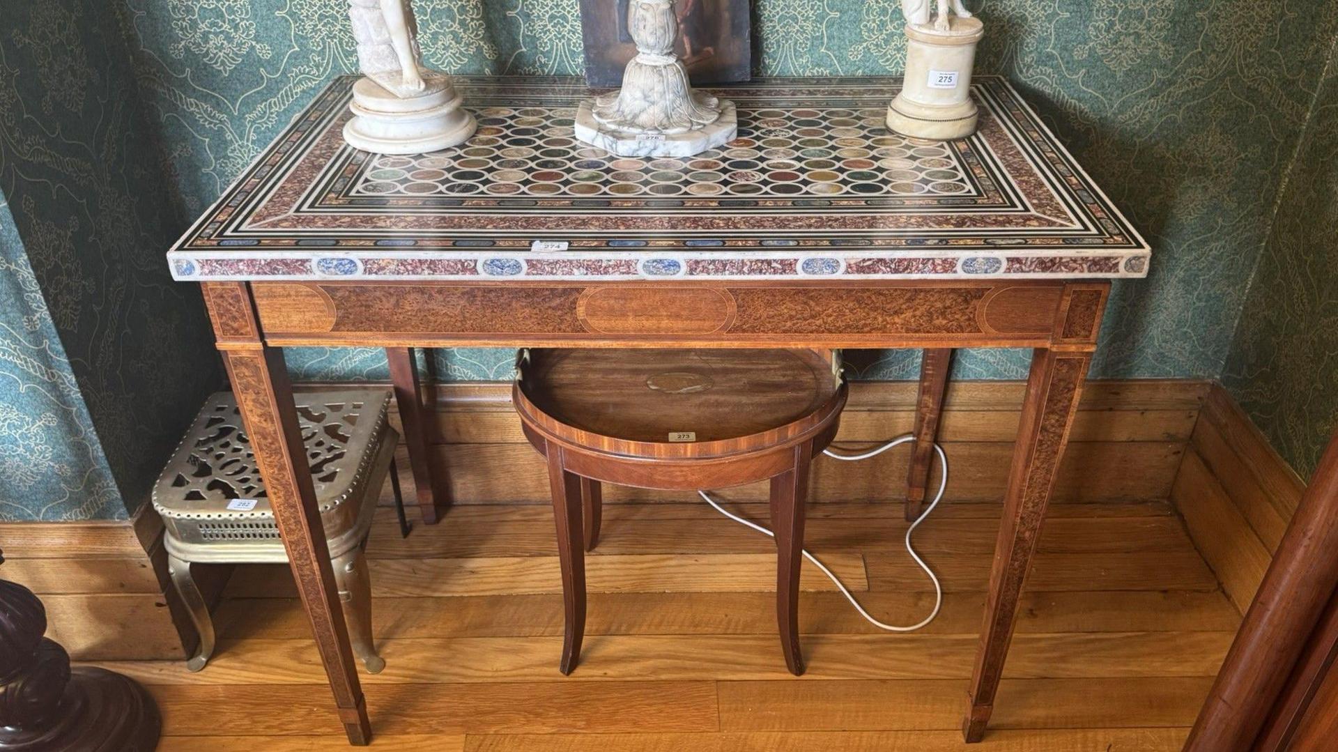 A multi-coloured marble-topped table which originated from Tandragee Castle.  The rare early 19th Century piece is raised on a burr walnut base and square tapered legs.