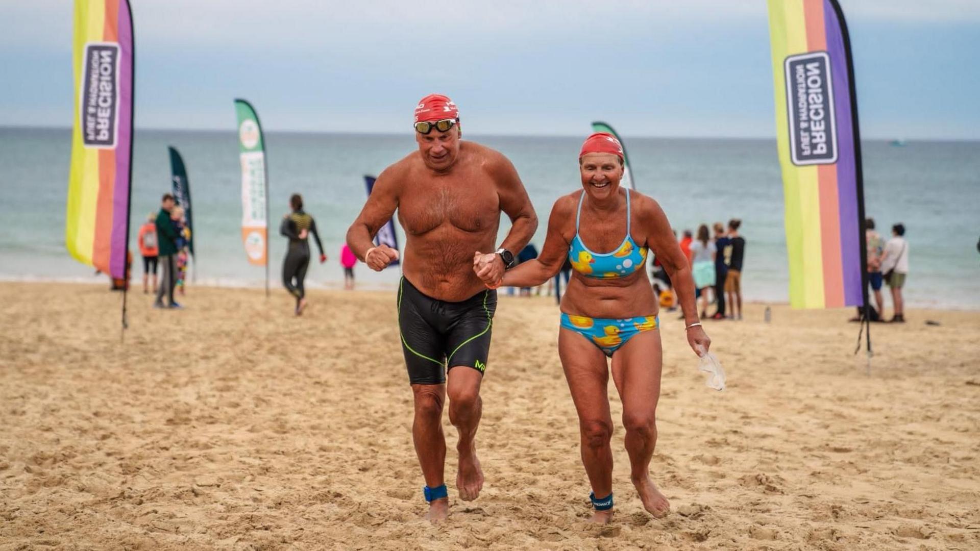 Sally Cheung and Jonathan Coe running on a beach