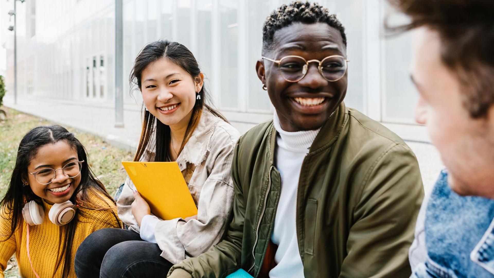 Student friends hanging out at university campus (stock photo)