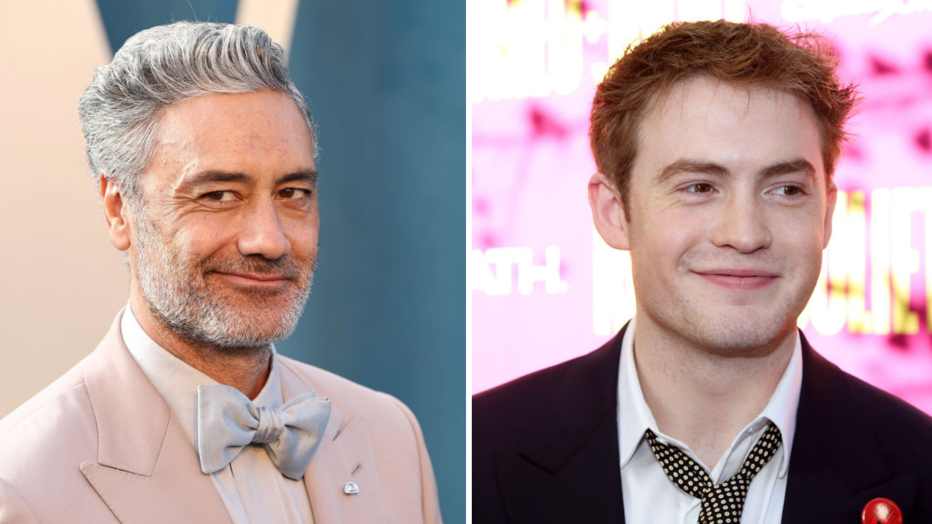 taika Waititi smiling in a pink suit jacket on the left, kit Connor smiling in a black suit jacket on the right.