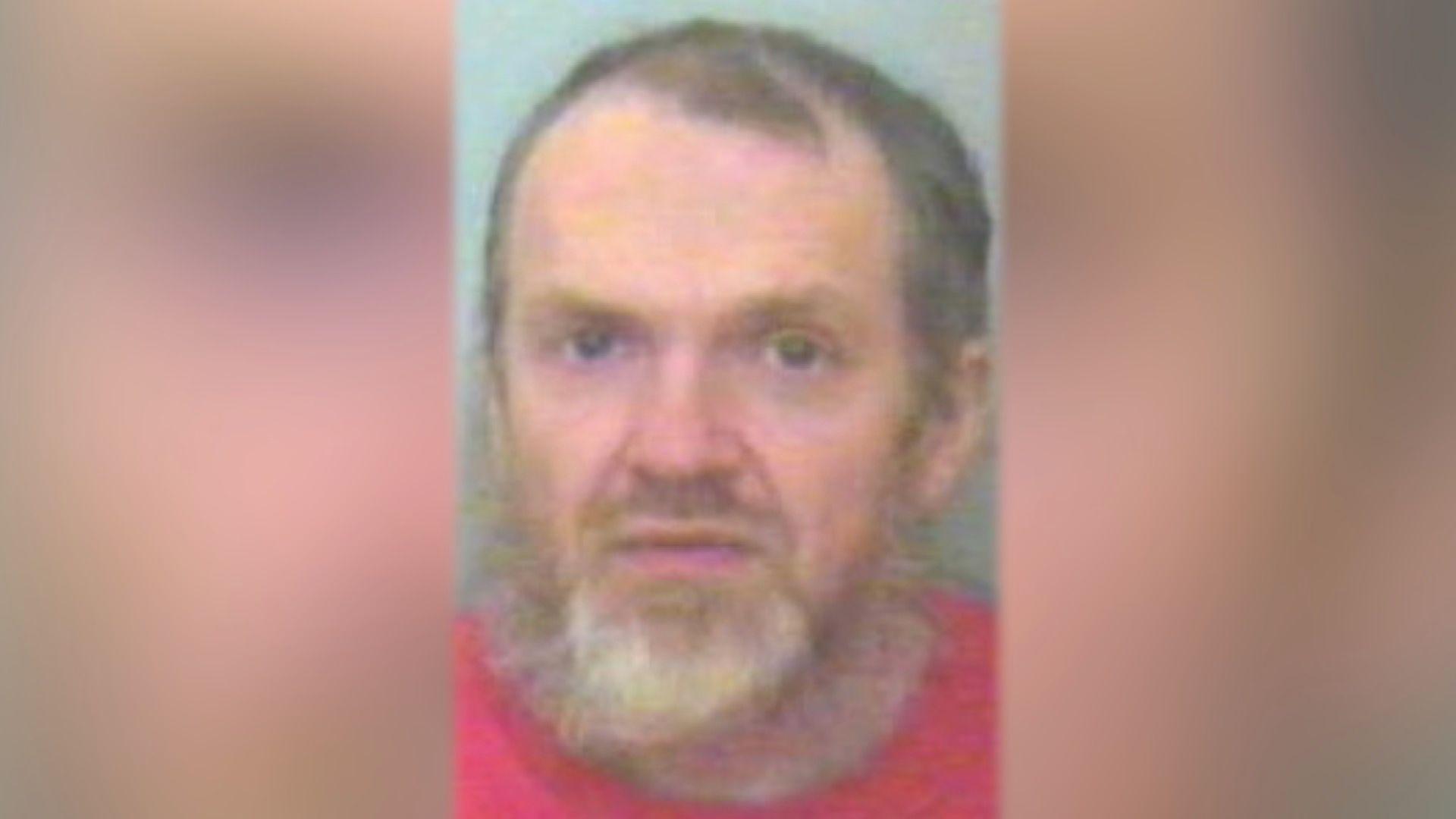 Roy Barclay looks directly at the camera. He is wearing a red T-shirt and has a beard.