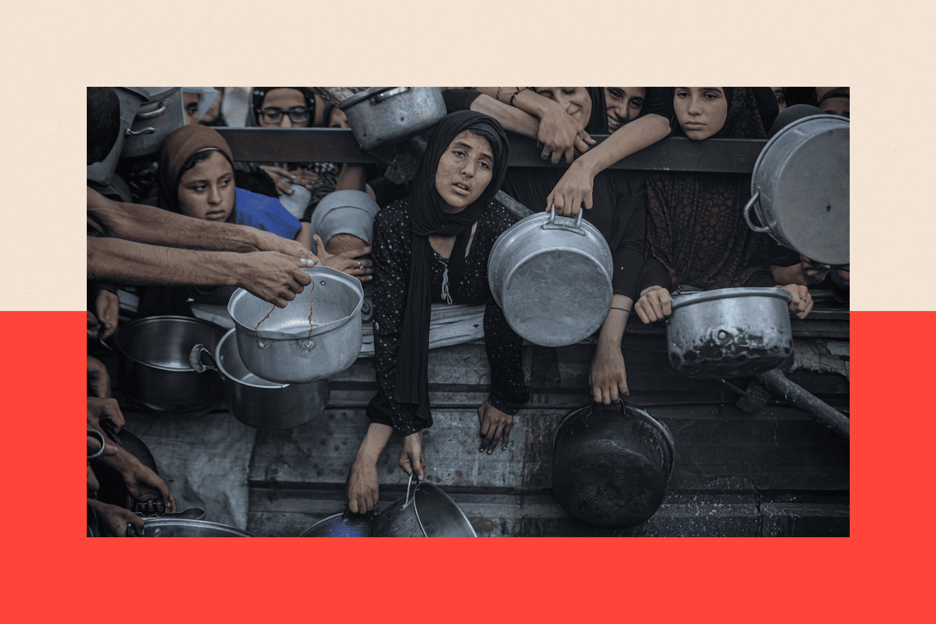Women and children wait in line with bowls and pans