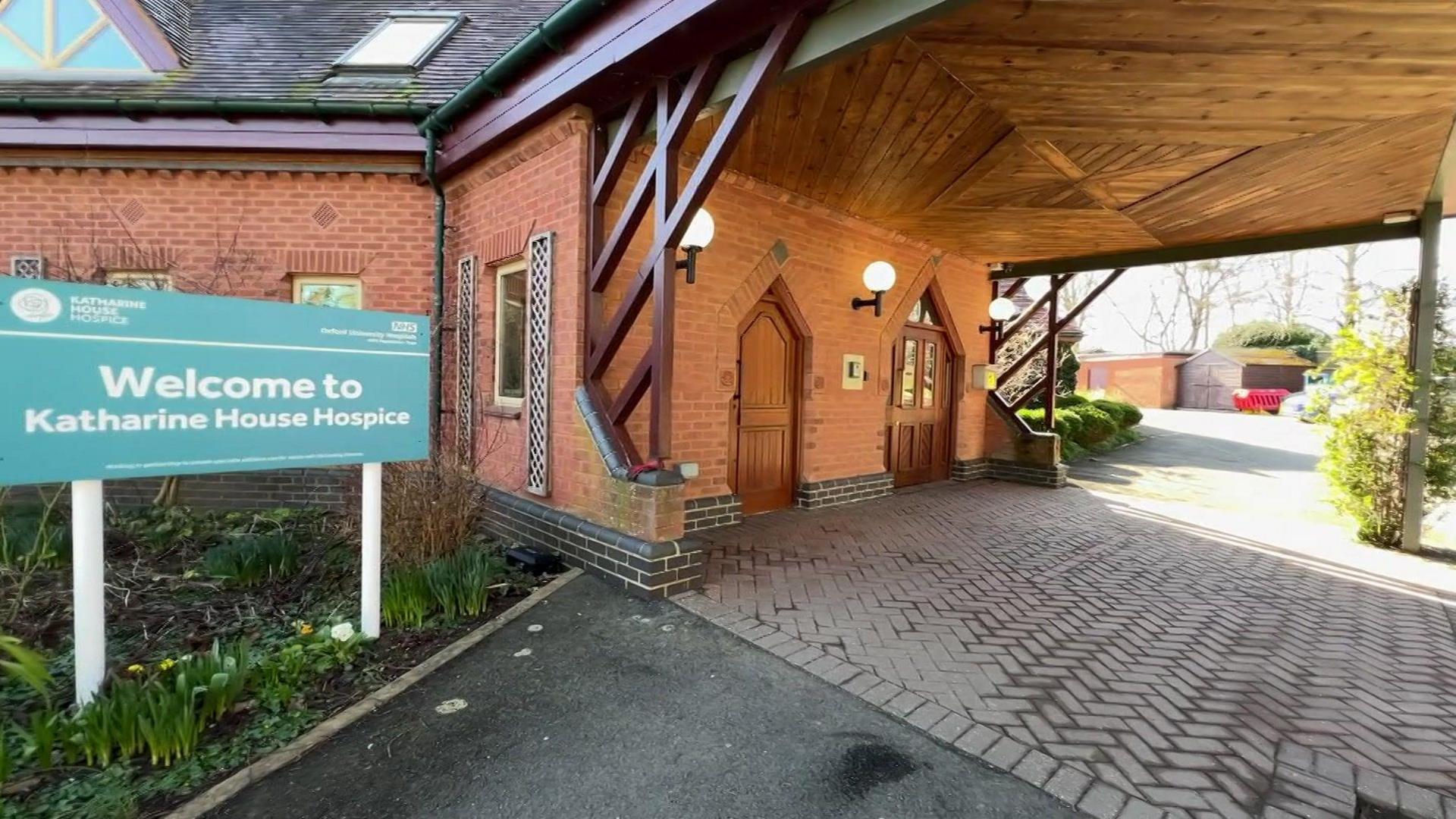 The front of Katharine House Hospice with a green welcome sign in front