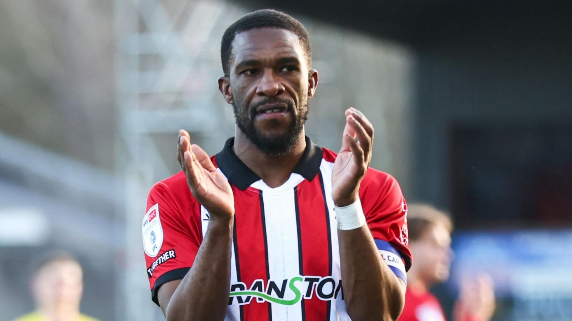 Tendayi Darikwa applauds the Lincoln City fans