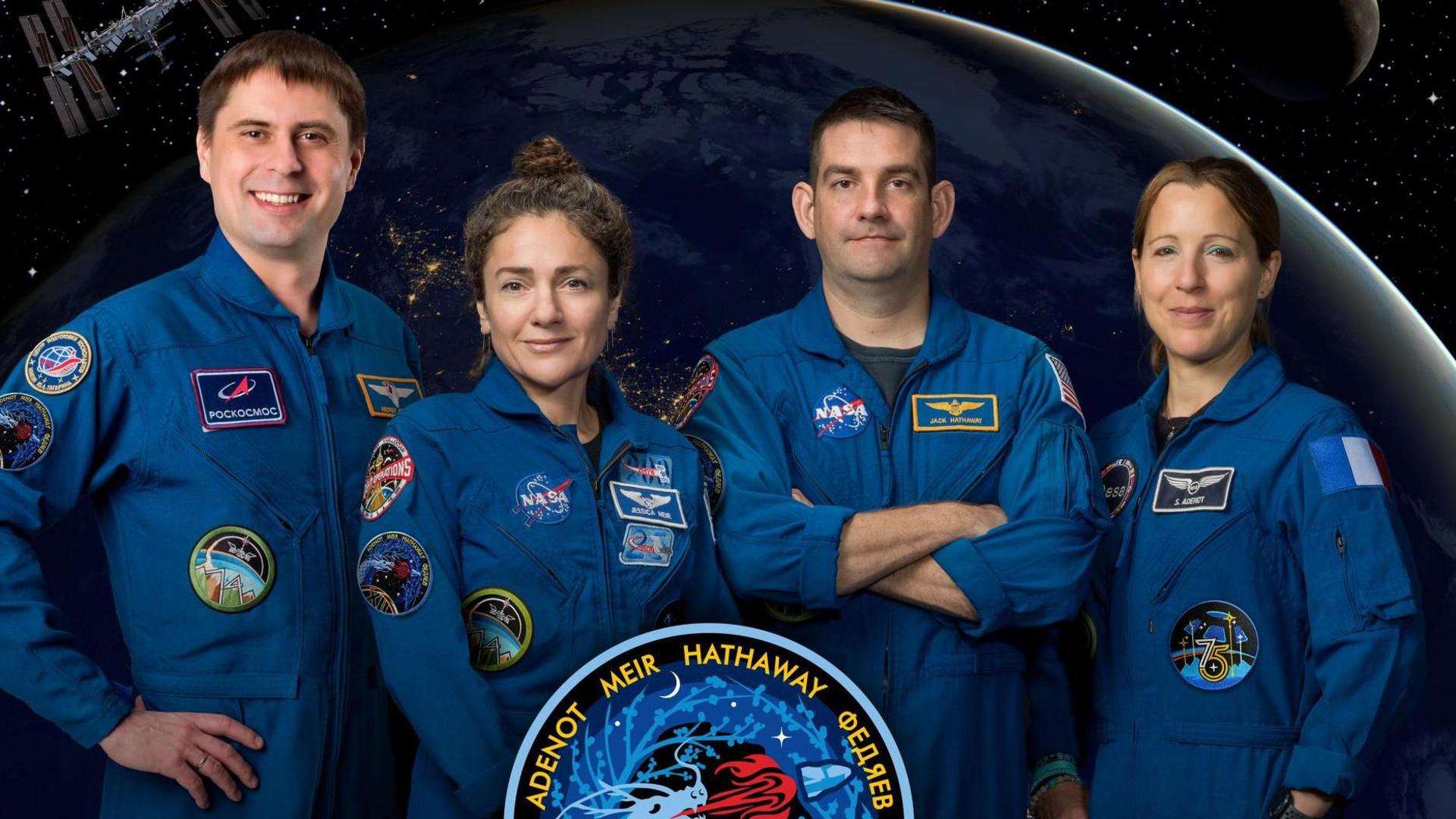 nasa crew 12 smiling for camera in blue jumpsuits