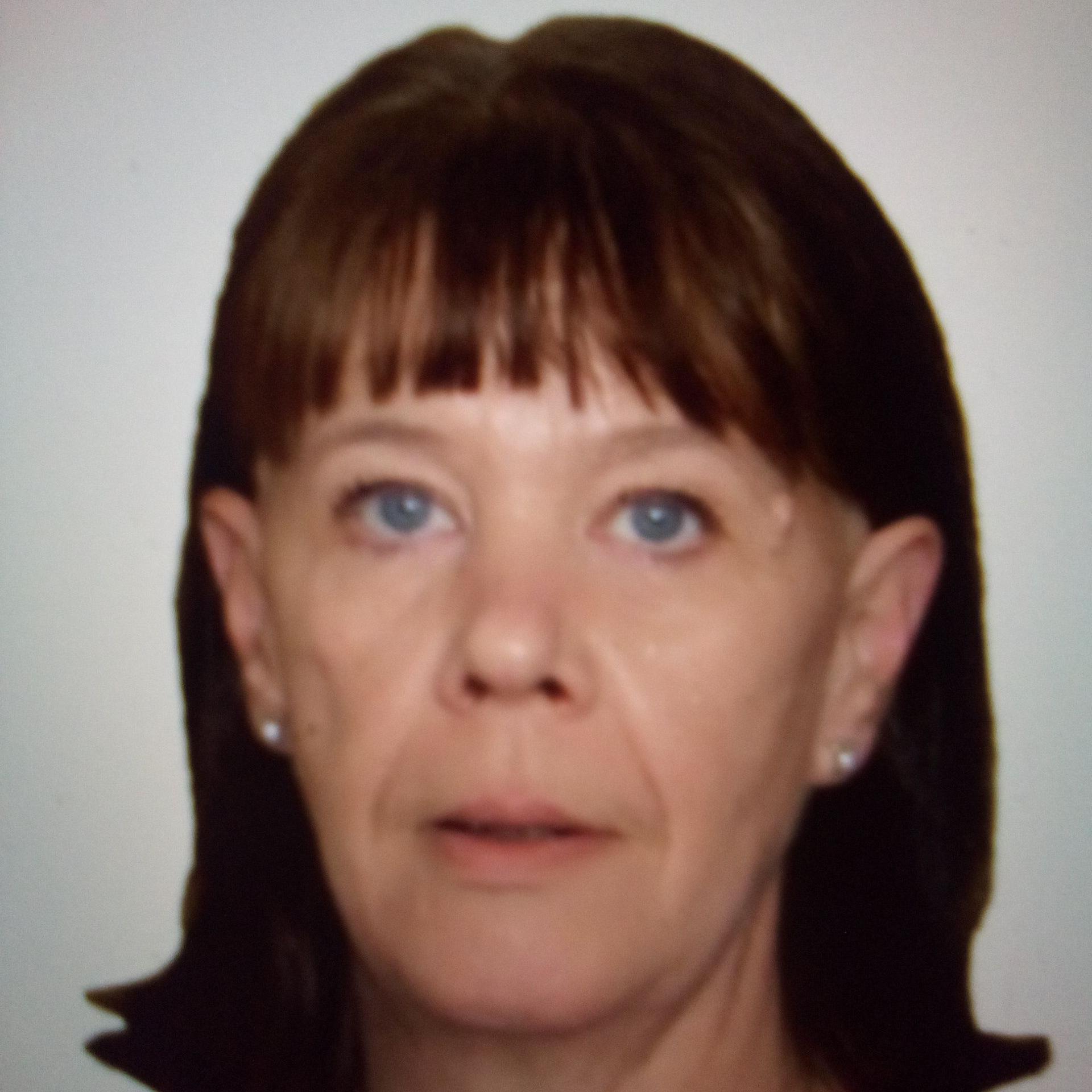 A woman with shoulder-length hair looking directly at the camera, with a white background