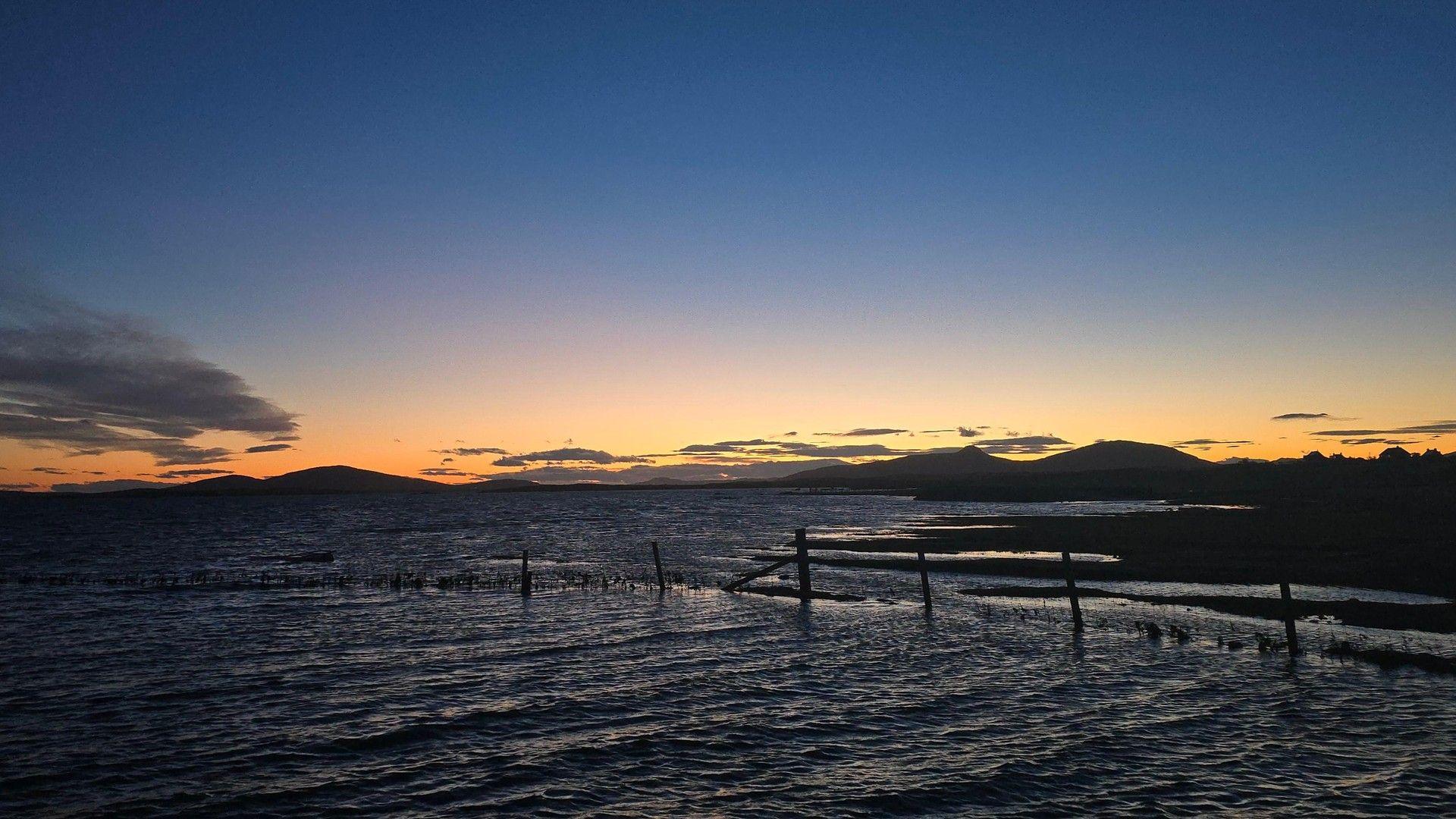 Late evening twilight glow behind hills and sea in the Western Isles, Scotland.