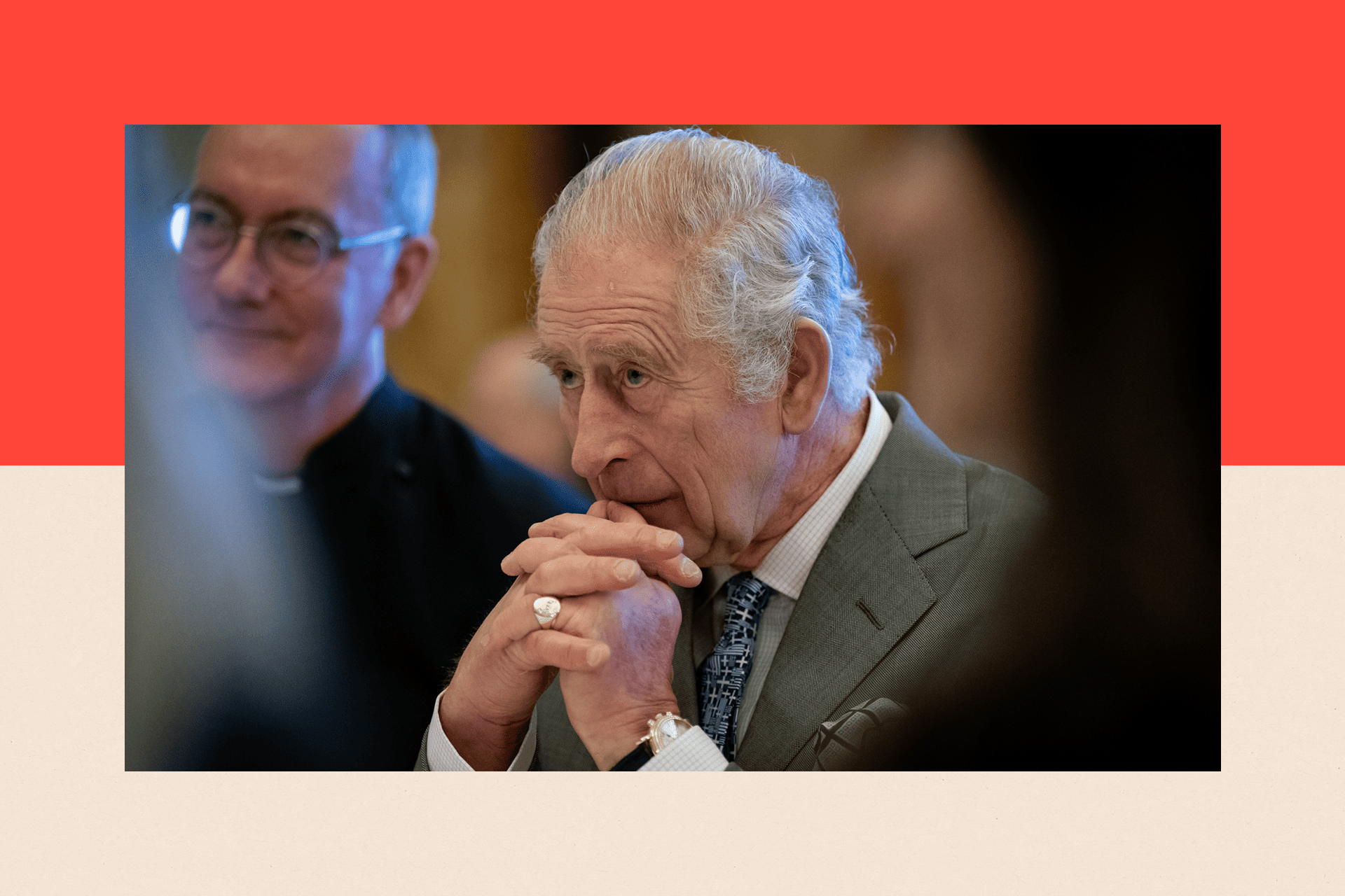 King Charles III with his hands held up to his face