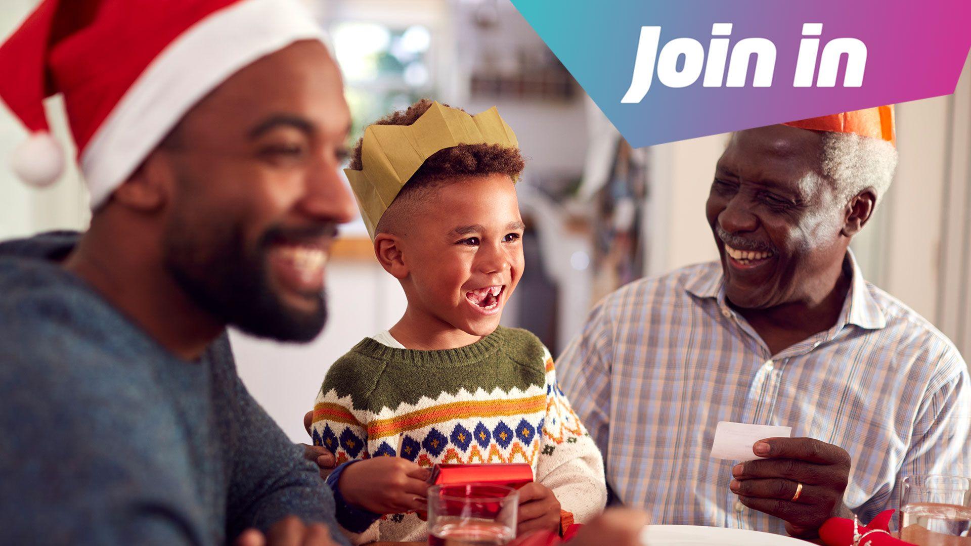 A family sit round the dinner table reading out Christmas cracker jokes and smiling 