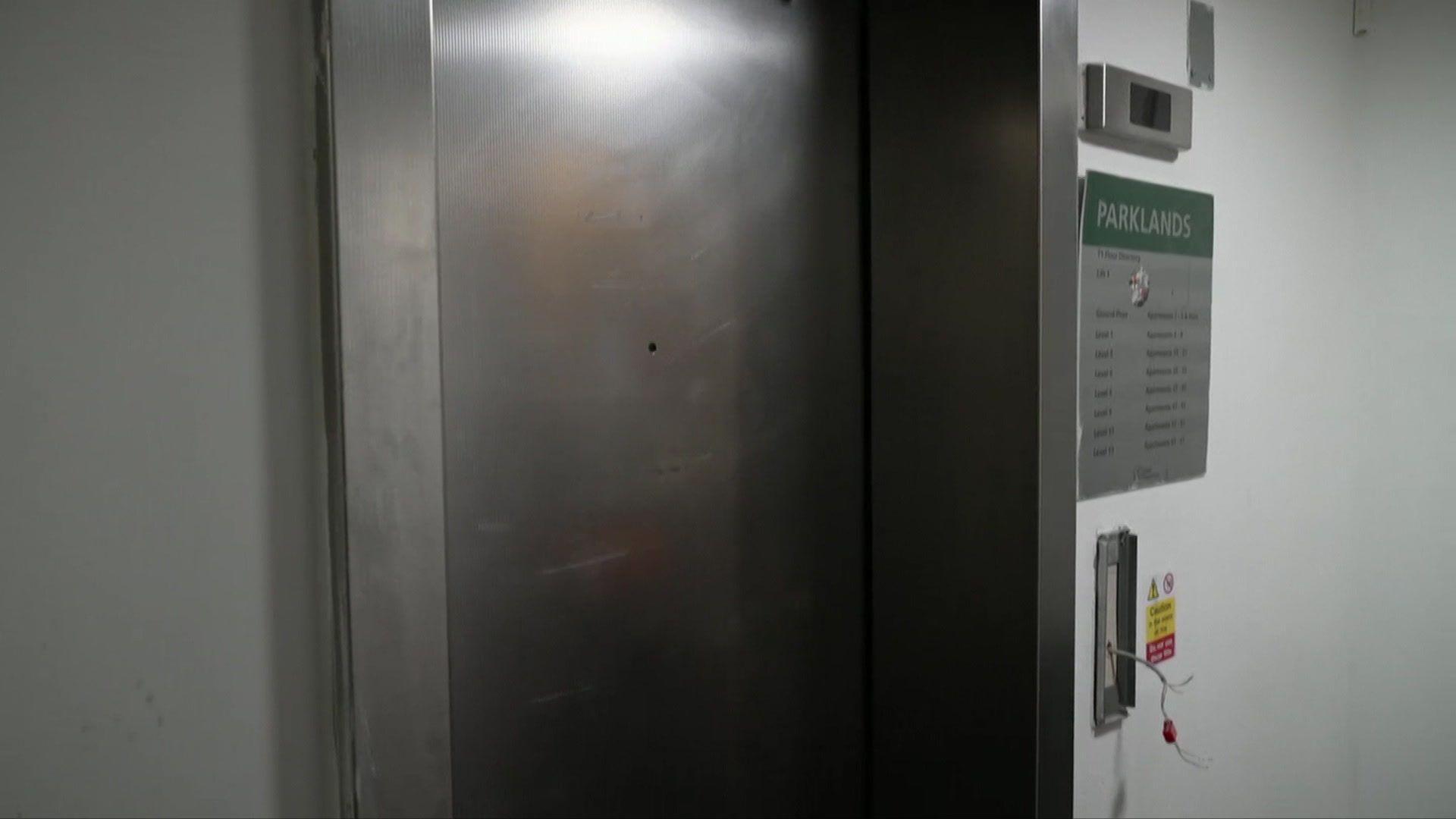 Image shows the broken lift in one of the blocks of flats. Wiring is sticking out of the control panel. 