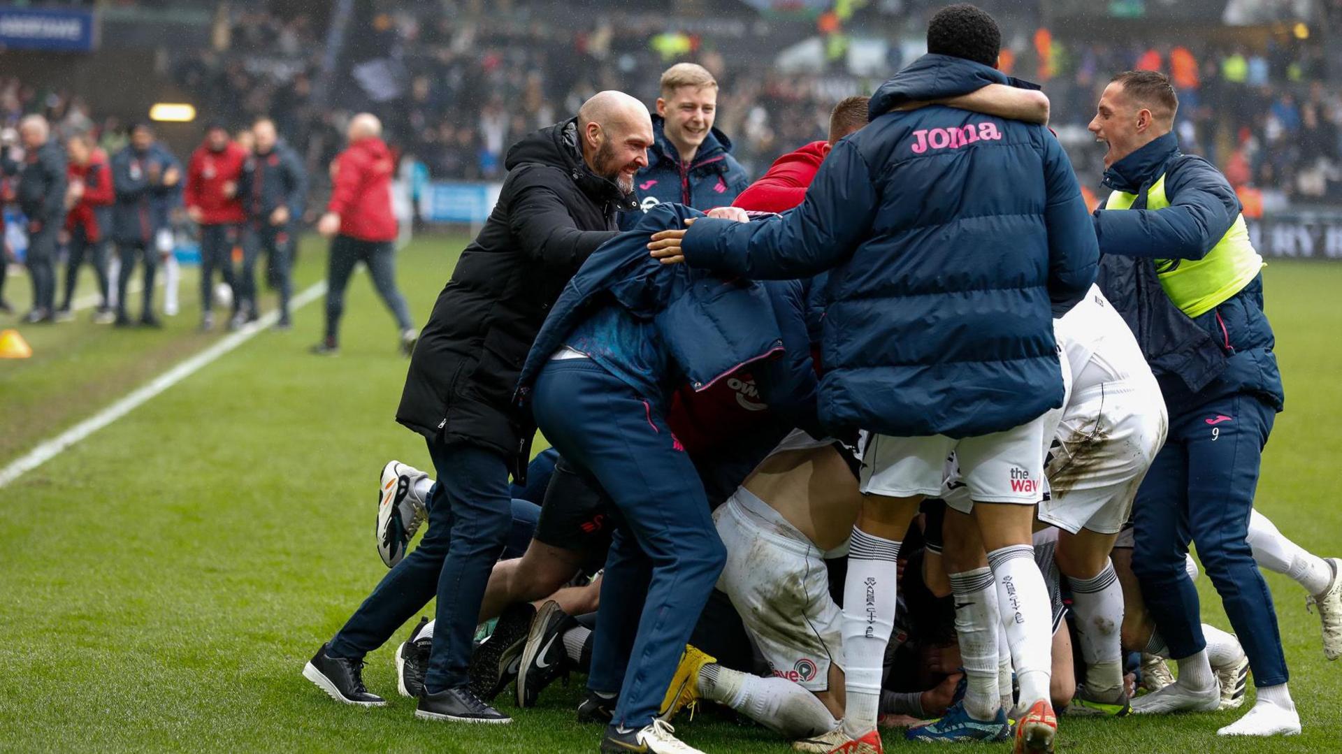 Swansea players and staff celebrate during March's win over Cardiff