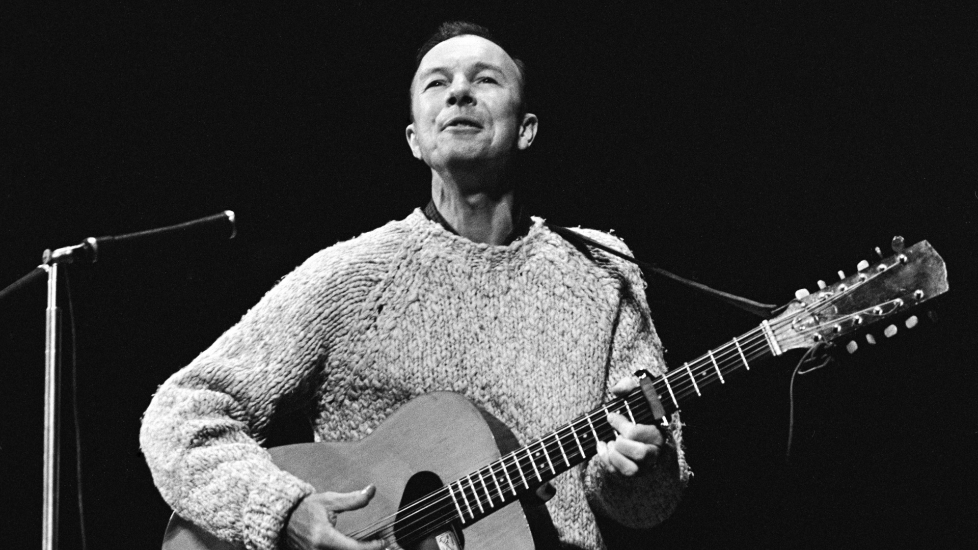 Dyn yn chwarae gitar
