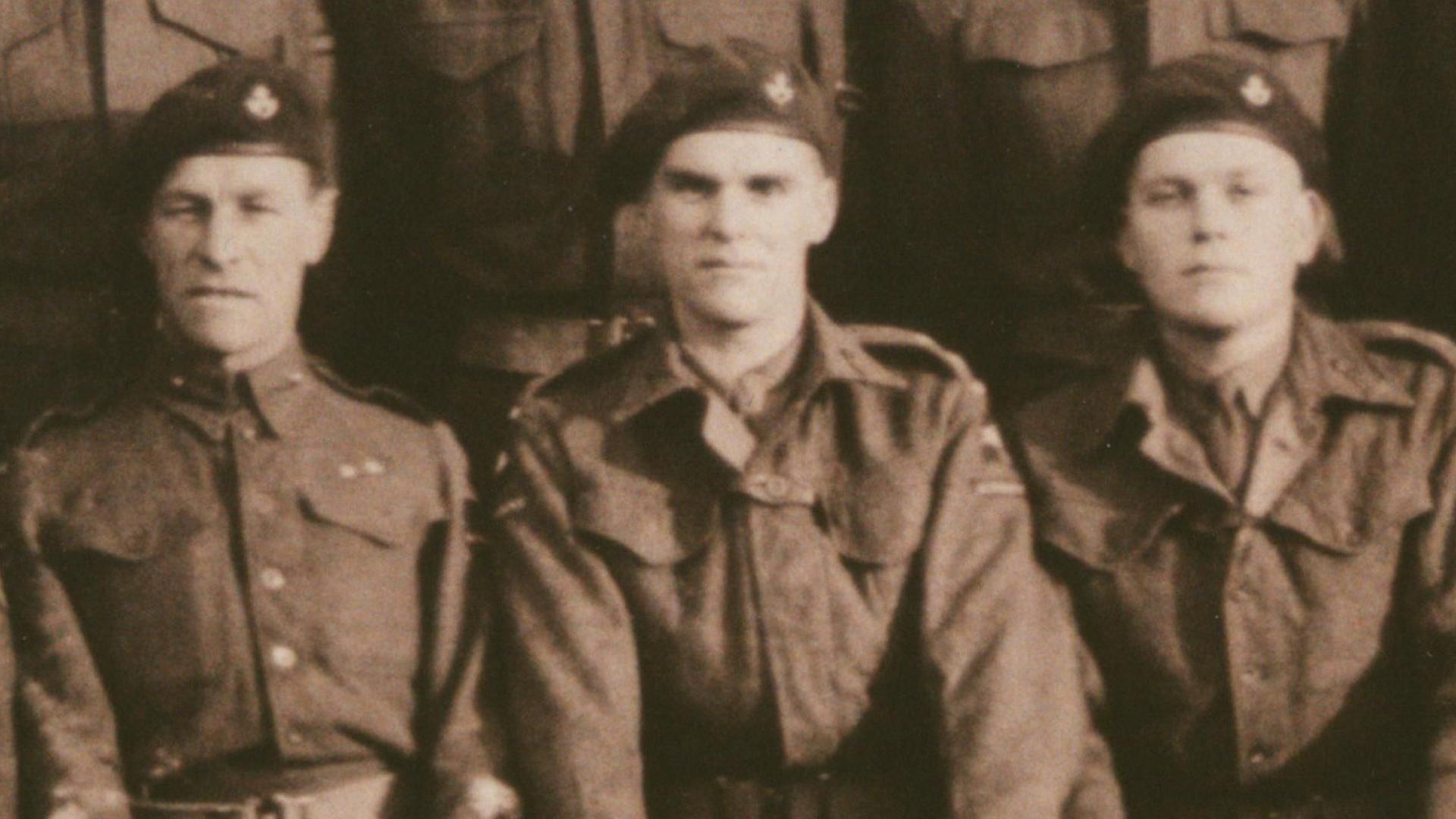 A sepia toned image of three soldiers in uniform in the 1940s