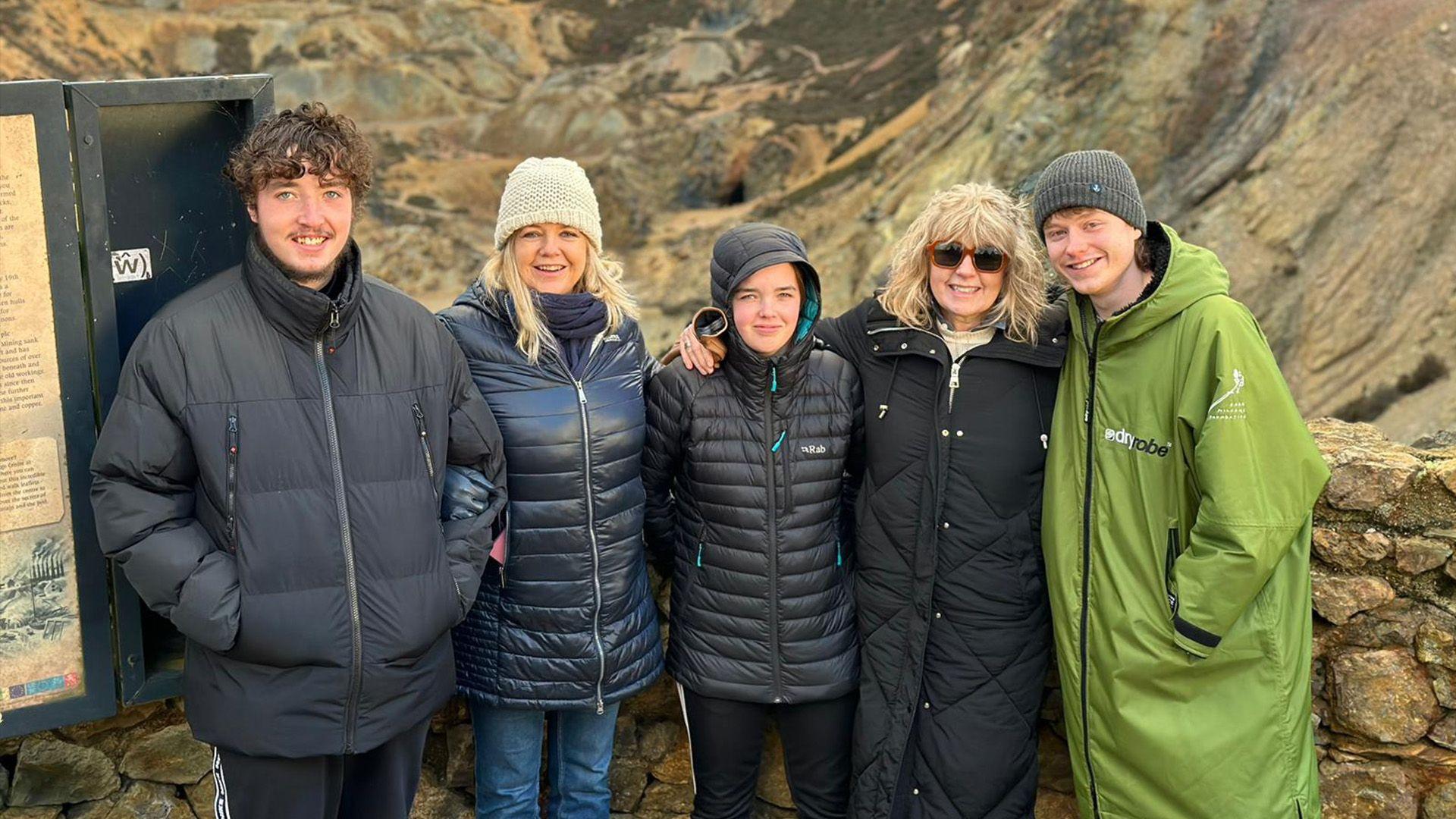 Gwïon a'i deulu yn sefyll o flaen Mynydd Parys, Ynys Môn