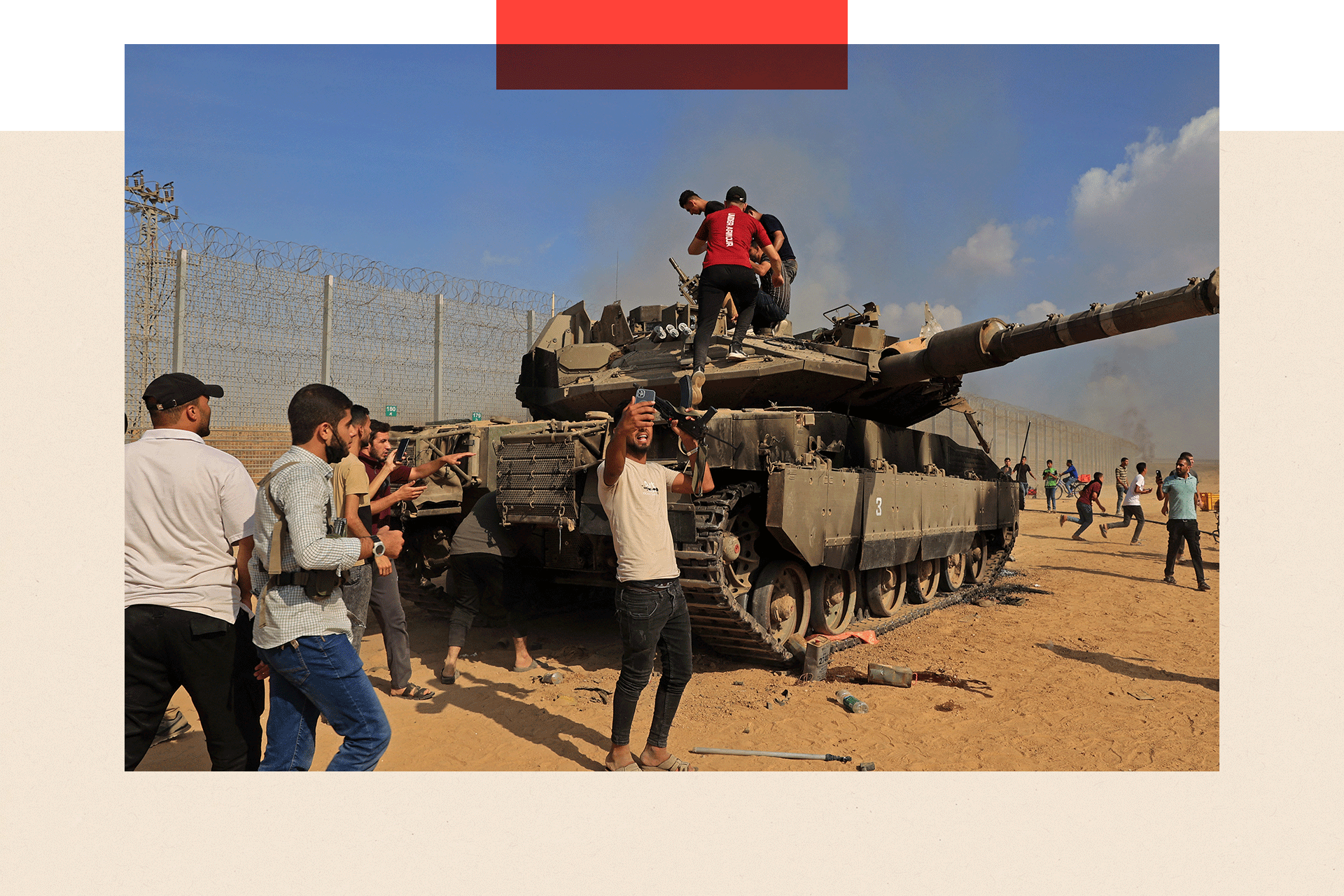 Palestinians take control of an Israeli Merkava battle tank after crossing the border fence with Israel from Khan Yunis in the southern Gaza Strip