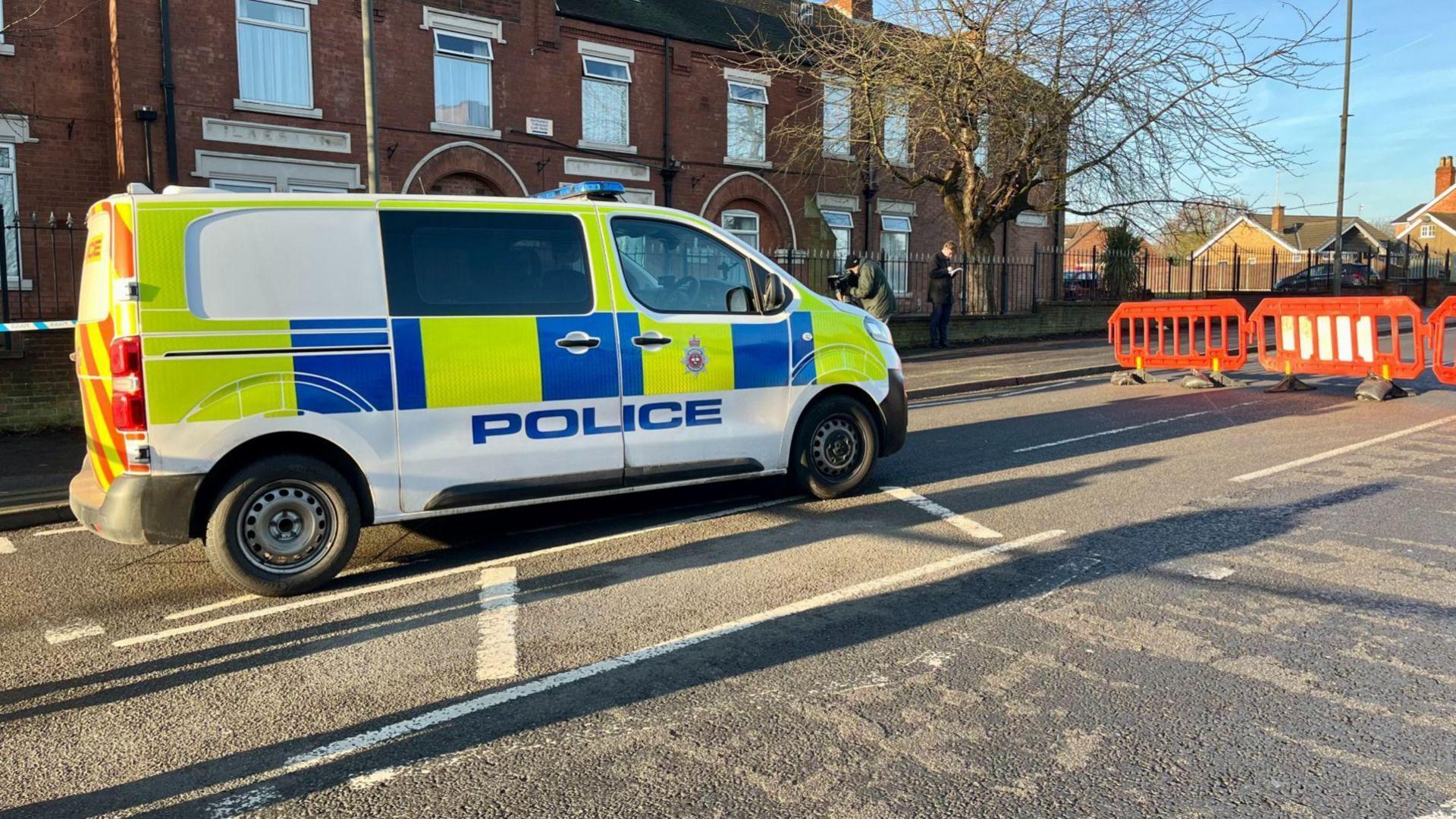 A police van parked up on a street.