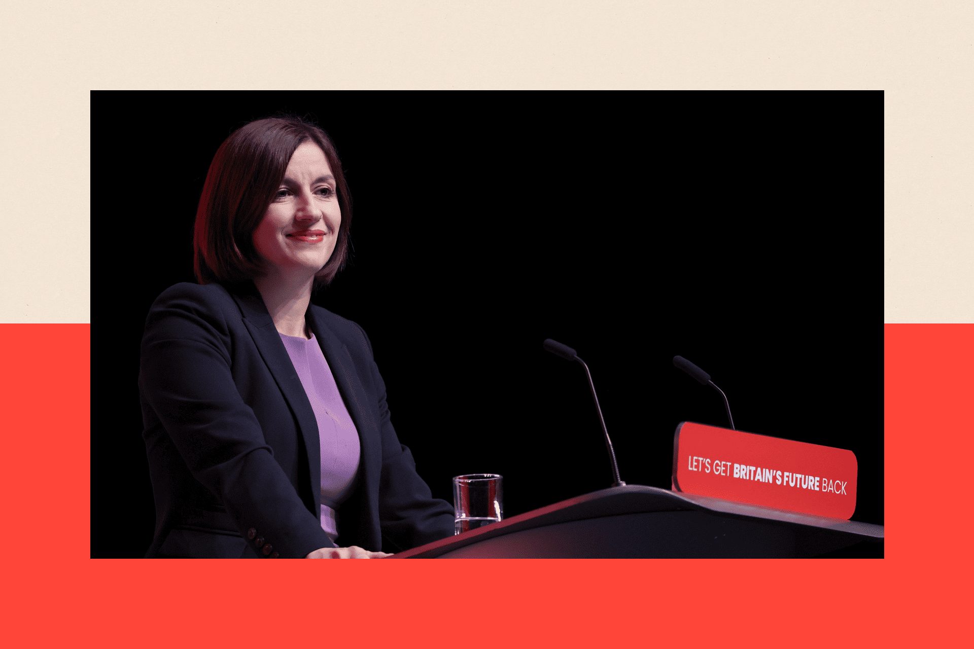 Bridget Phillipson, wearing a black blazer and a purple top, stands at a lectern in front of a black background while delivering a speech.