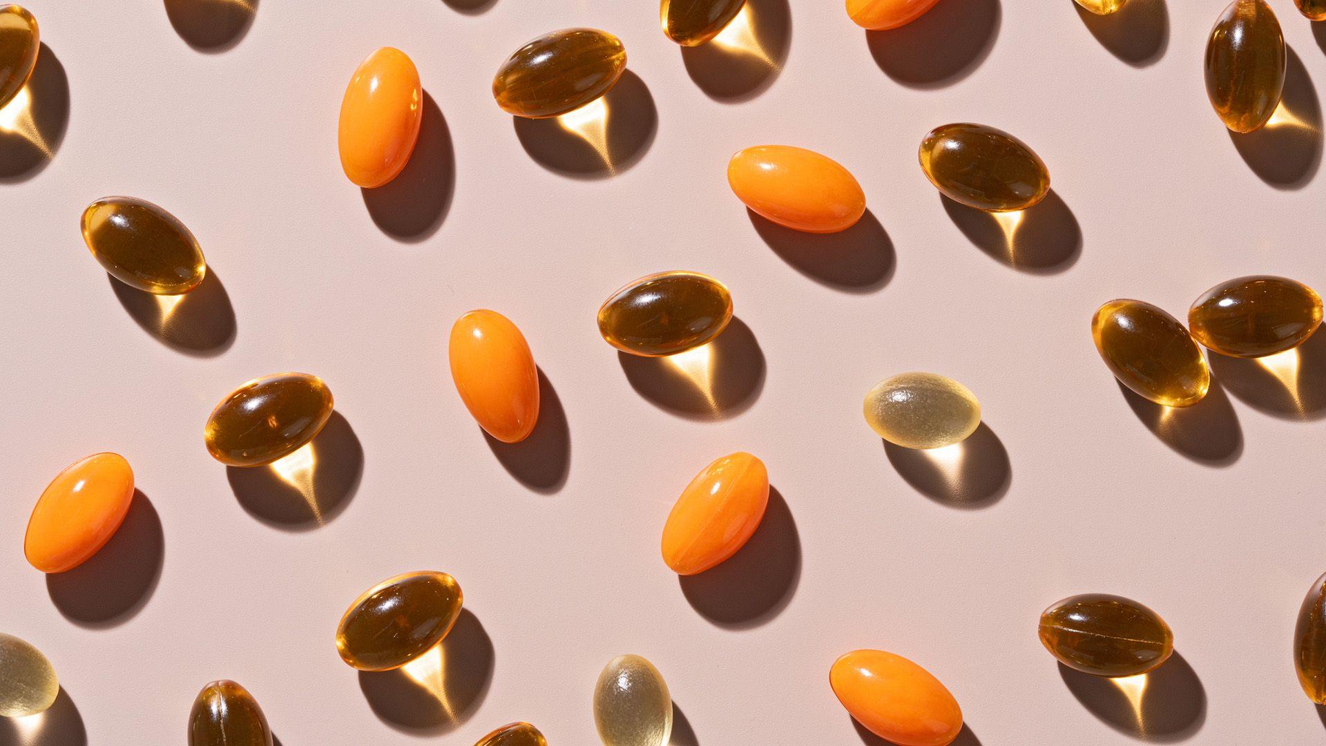 Various soft gel capsules on beige background