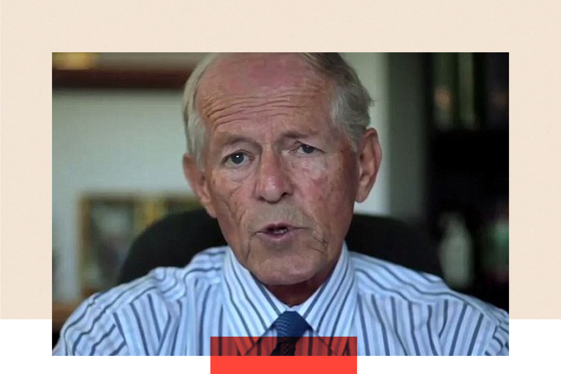 A close-up of John Smyth speaking directly to the camera. His mouth is slightly open, and he is dressed in a white and blue striped shirt. He sits on a black chair, with a blurred background.