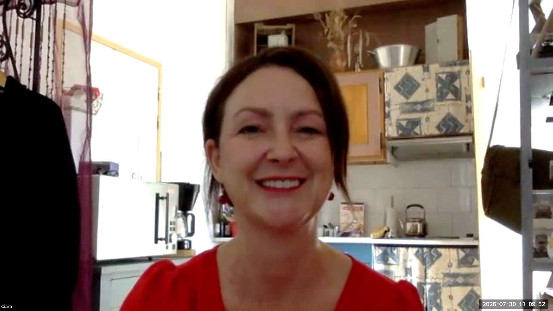 A woman with brown hair smiles at the camera