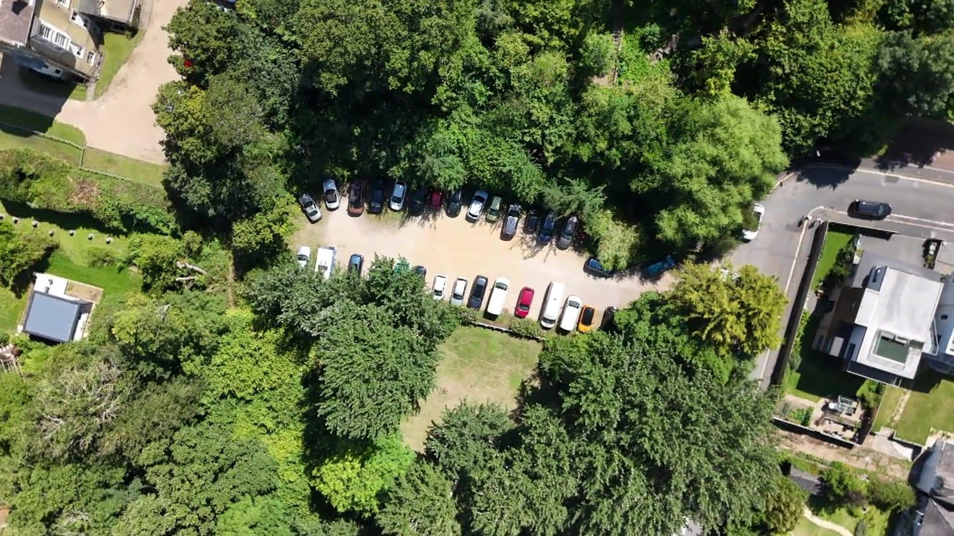 A drone shot of mornington road car park with trees encircling the car park where cars can be seen.