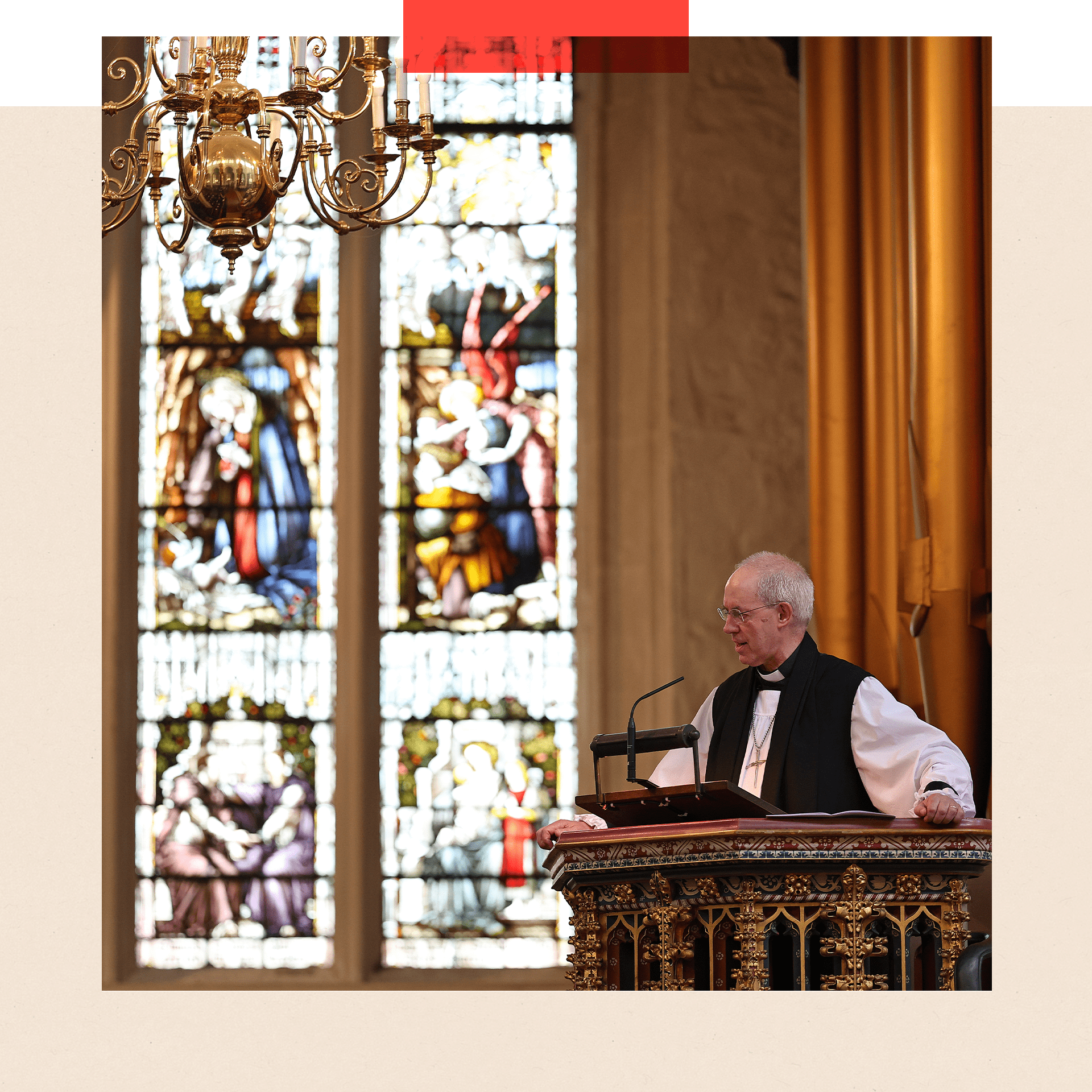 The Archbishop of Canterbury speaks from a pulpit in front of a stained-glass window