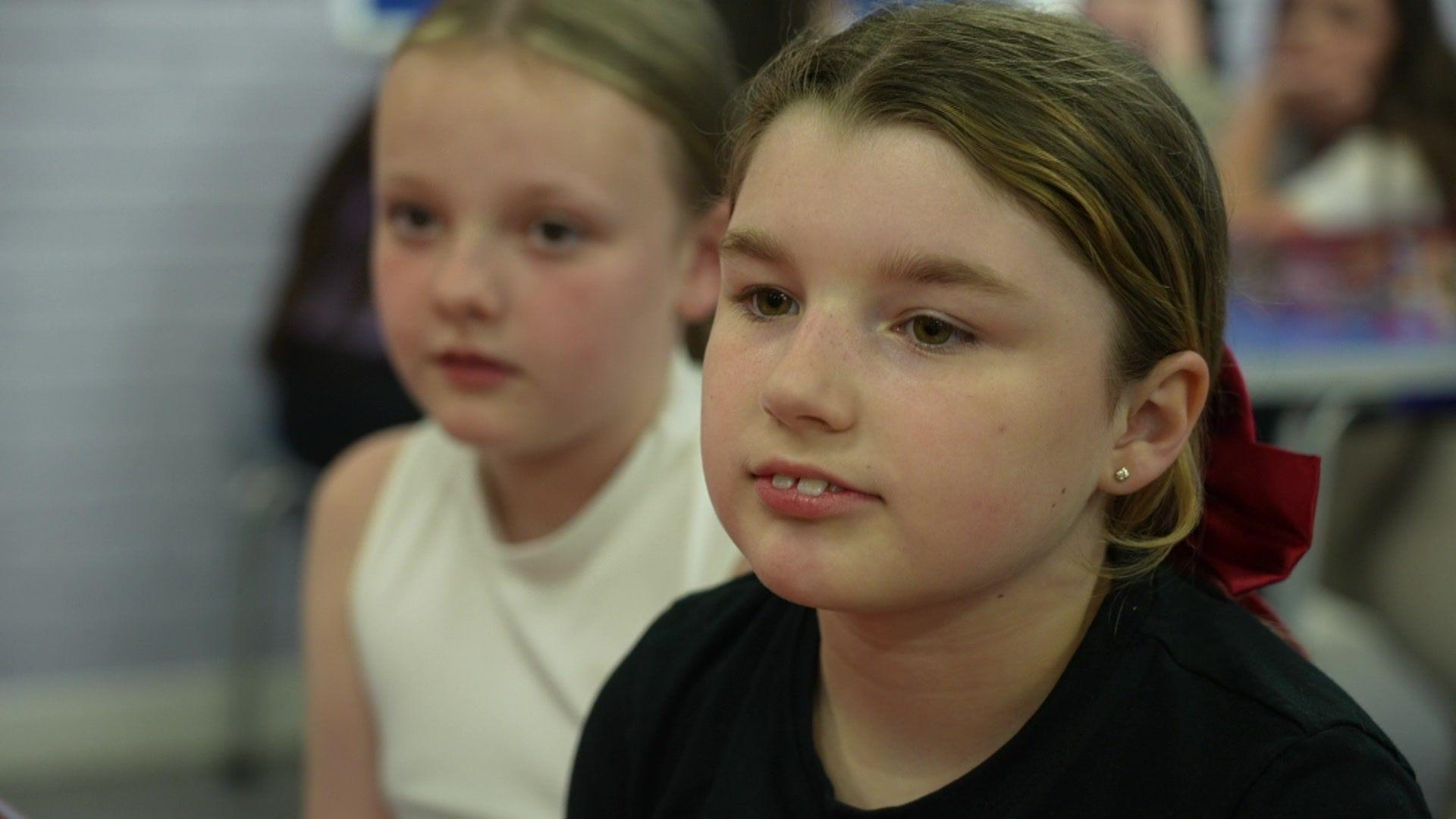 Scarlett sits with a friend discussing her pocket money