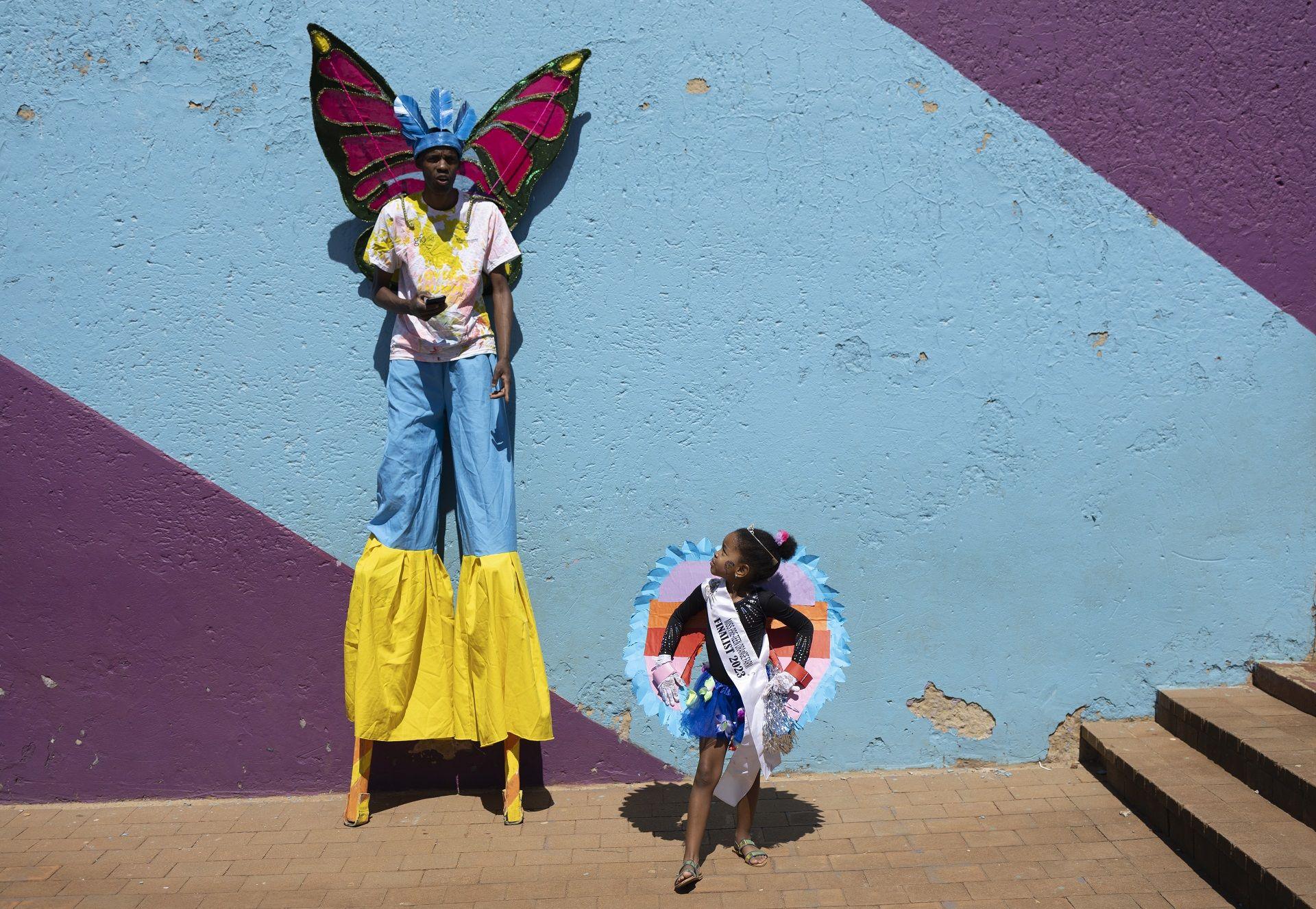 Stilt-walker Andile Sohe (32) and Miss Preteen Orange Farm, Thando Mbatha (7) pose for the camera.