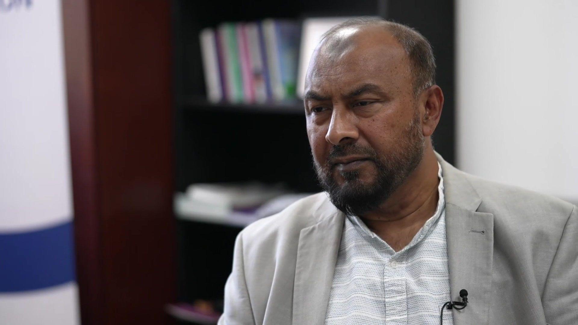 Dilowar Khan in a white shirt and grey suit jacket.