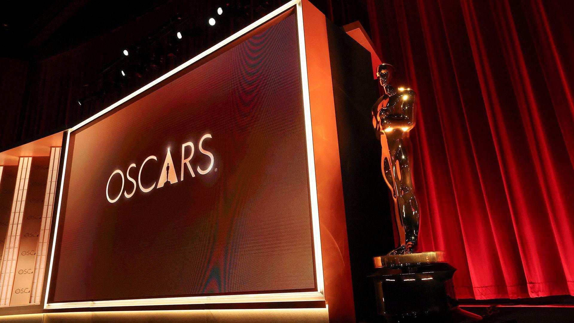 A big sign saying Oscars next to one of the tophies