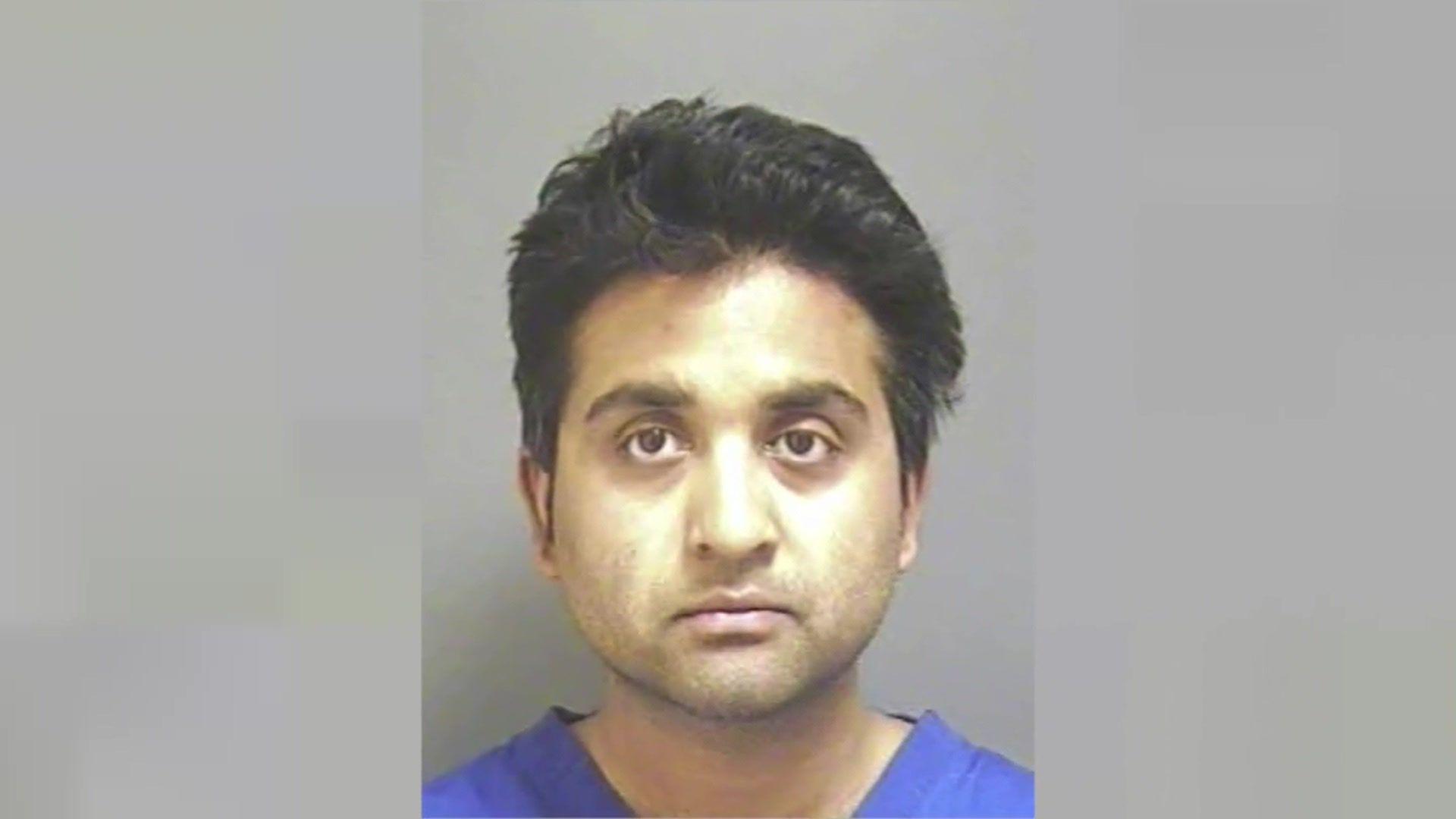 Police mugshot of Salil Korambayil, who has black hair and is wearing a blue t-shirt