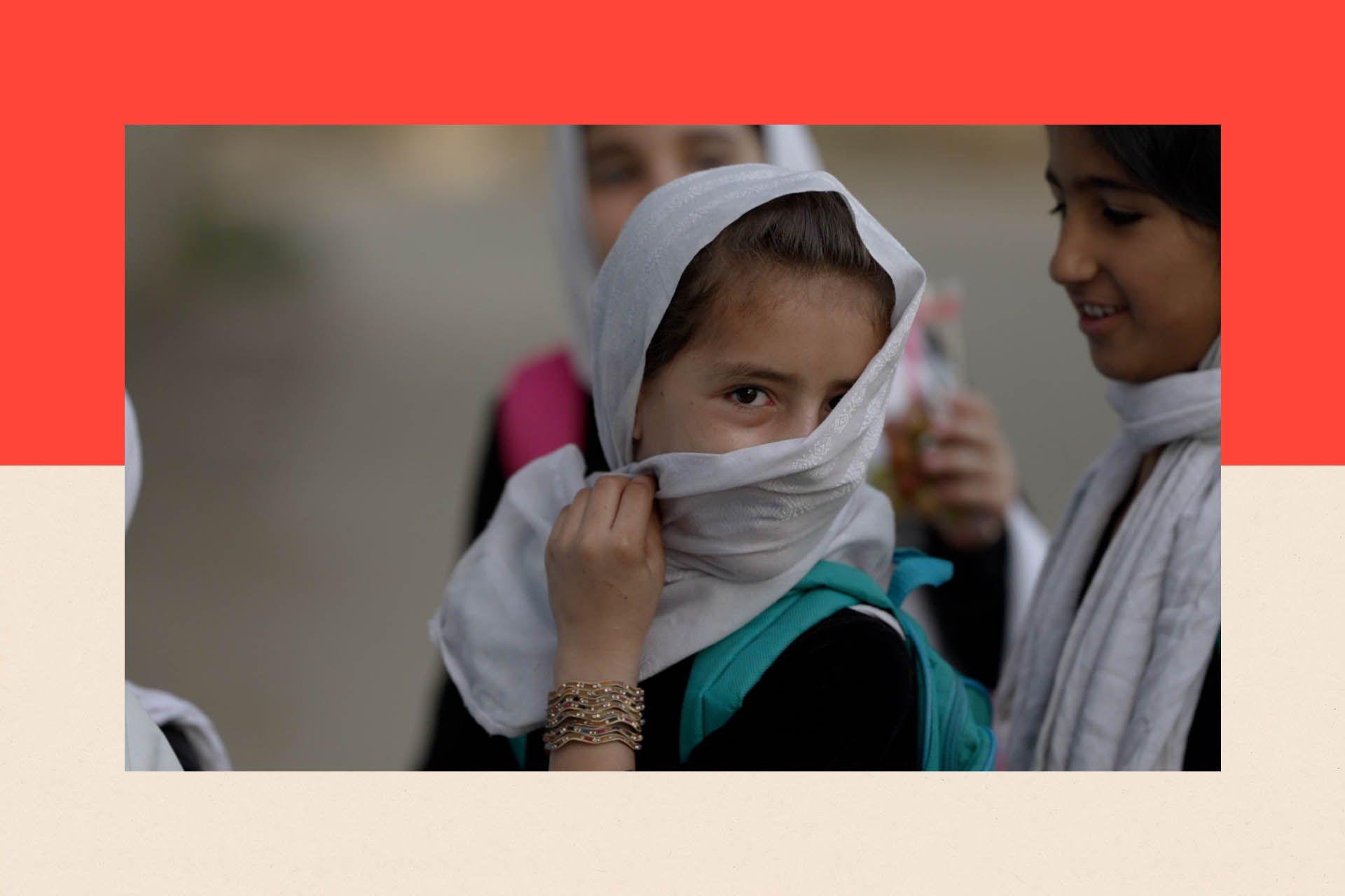 A girl hides her face behind a white hijab