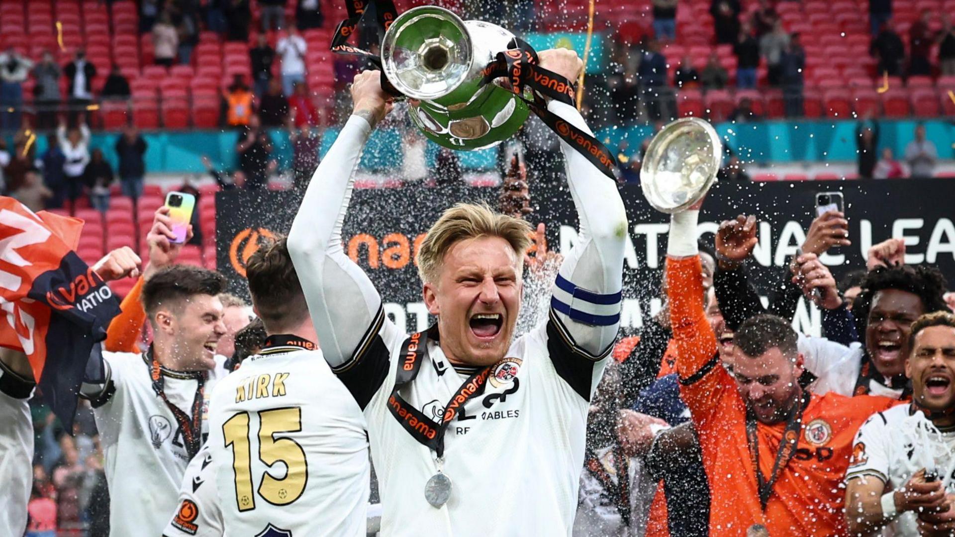 Bromley captain Byron Webster holding aloft the National League play-off final trophy