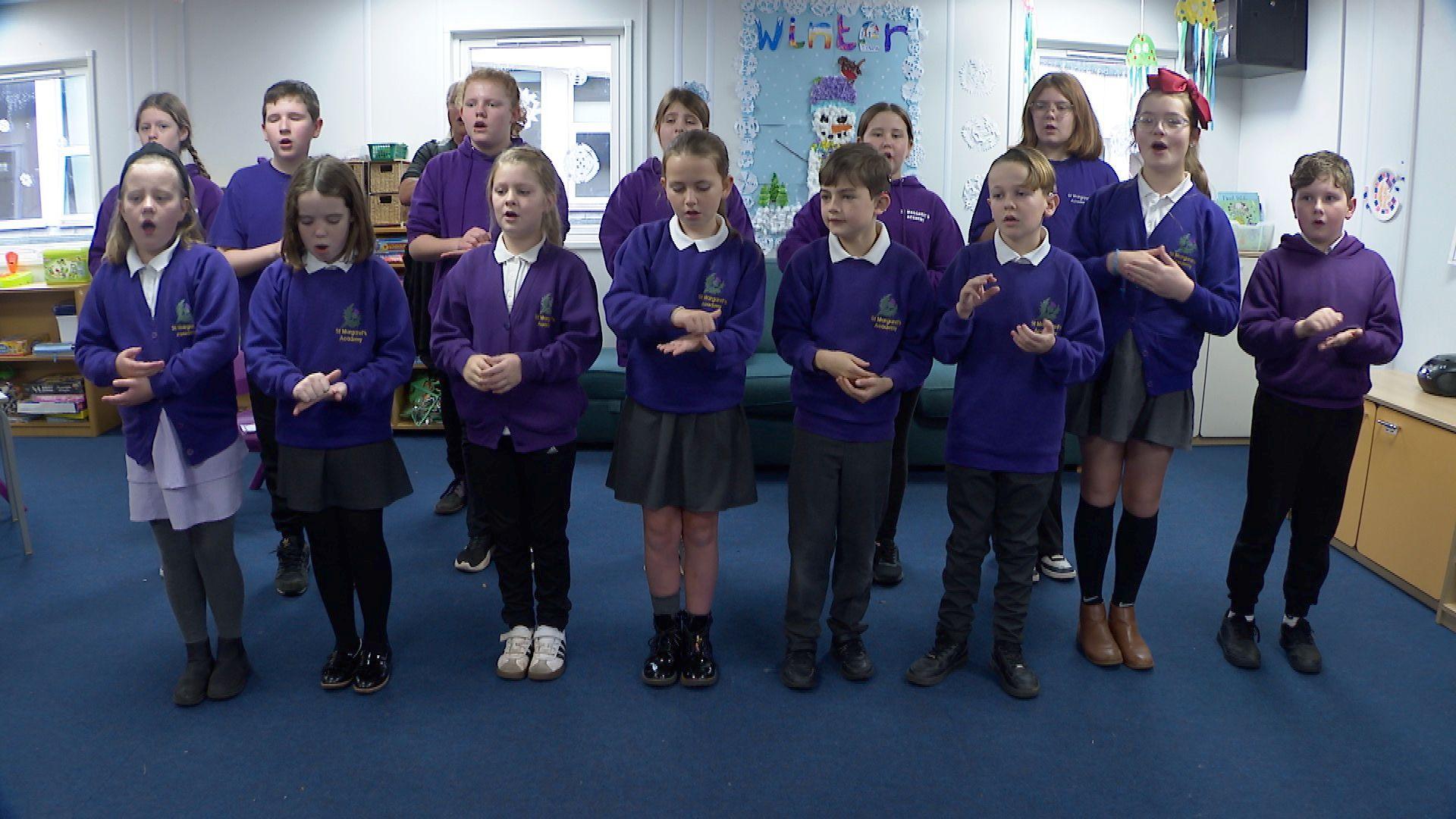 A children's choir from St Margaret's Academy using British Sign Language while singing a Christmas carol